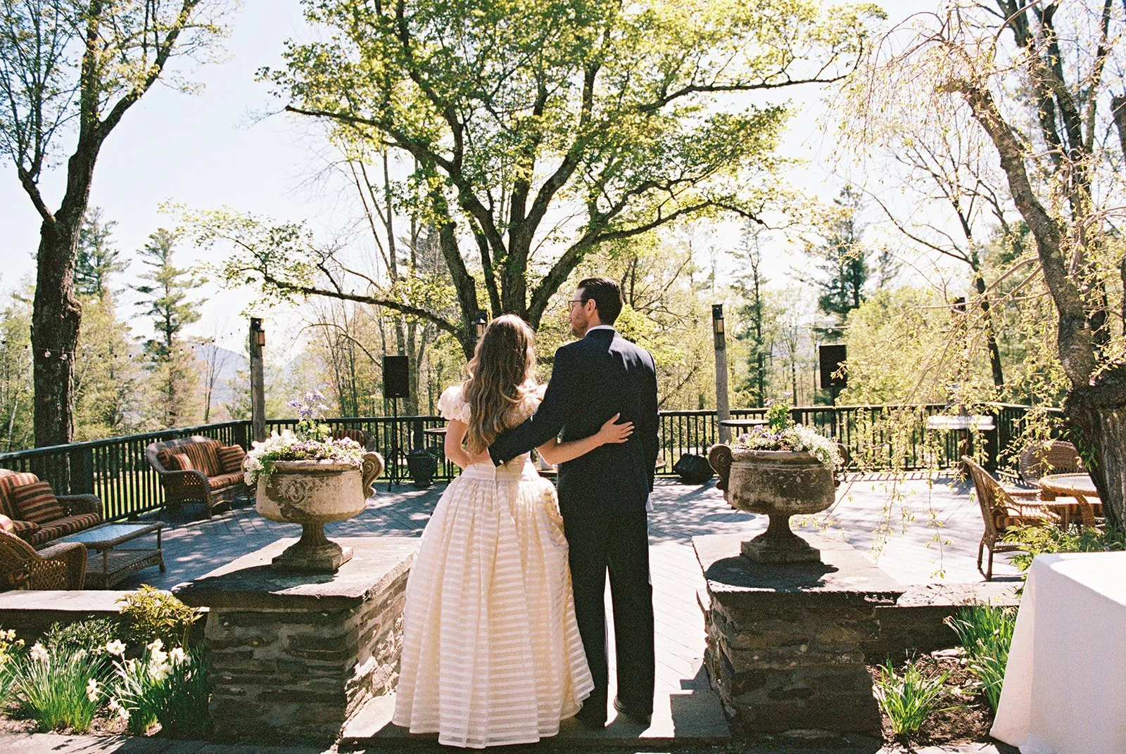 Film photo of the bride and groom standing together and overlooking the terrace at Deer Mountain Inn.
