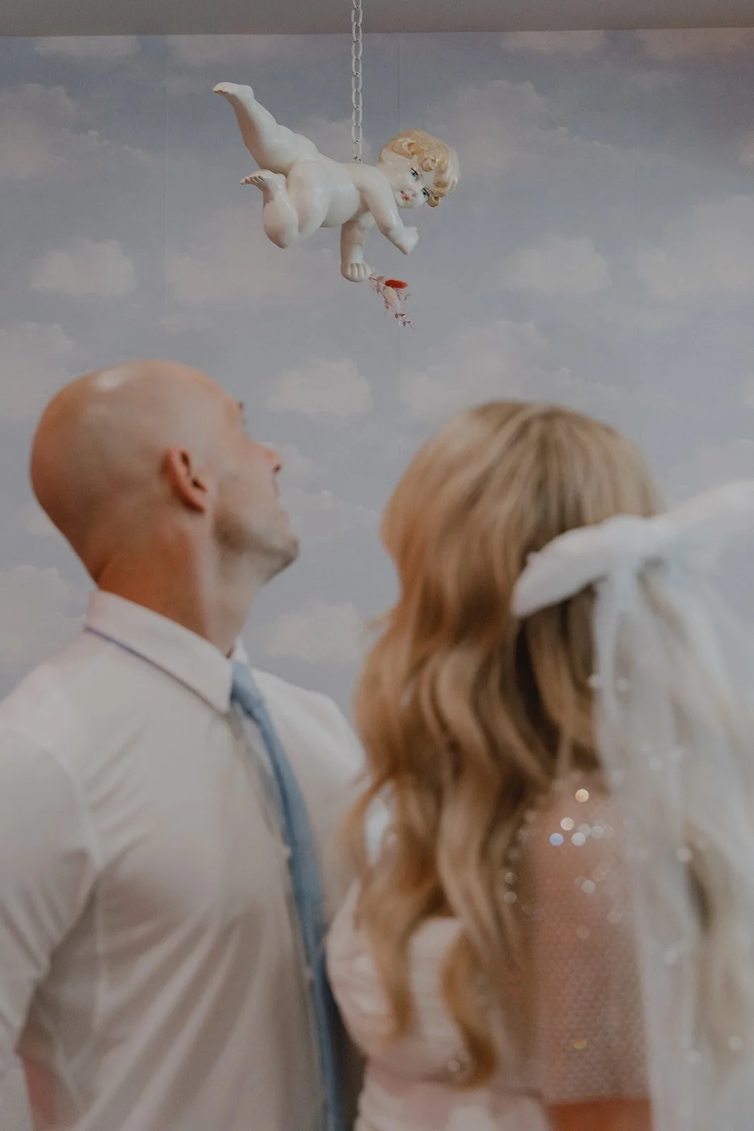 Couple looking up at the hanging cherub inside Sure Thing Chapel during their micro wedding.