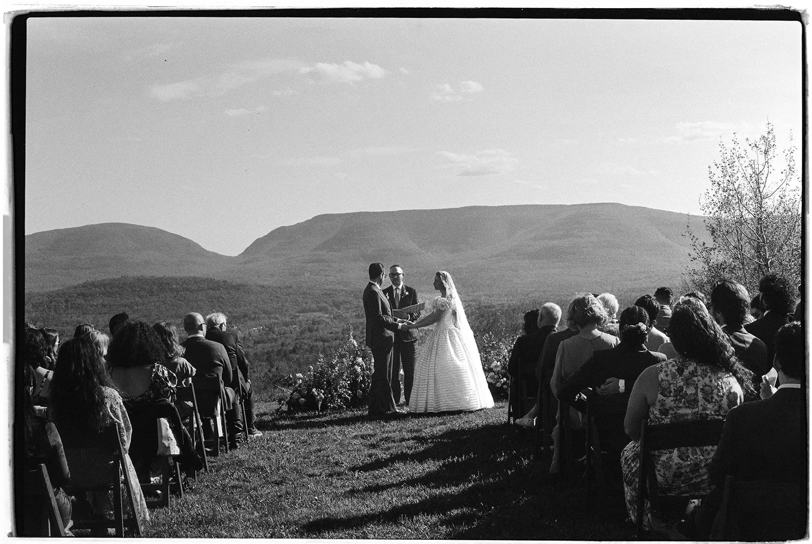 Black and white film photo of a bride and groom exchanging vows during their Northern Catskill Mountain wedding ceremony on film.