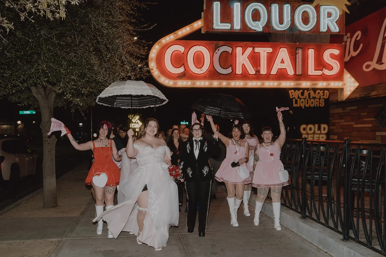 Bride smiling under an umbrella during a New Orleans style second line wedding parade in Las Vegas.