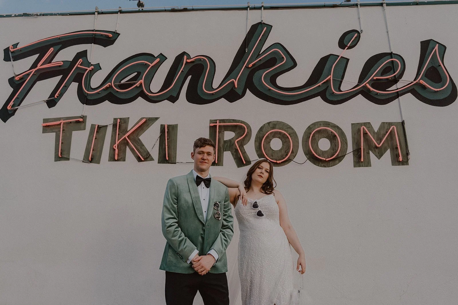Couple posing against the exterior of Frankie's Tiki Room in Las Vegas.