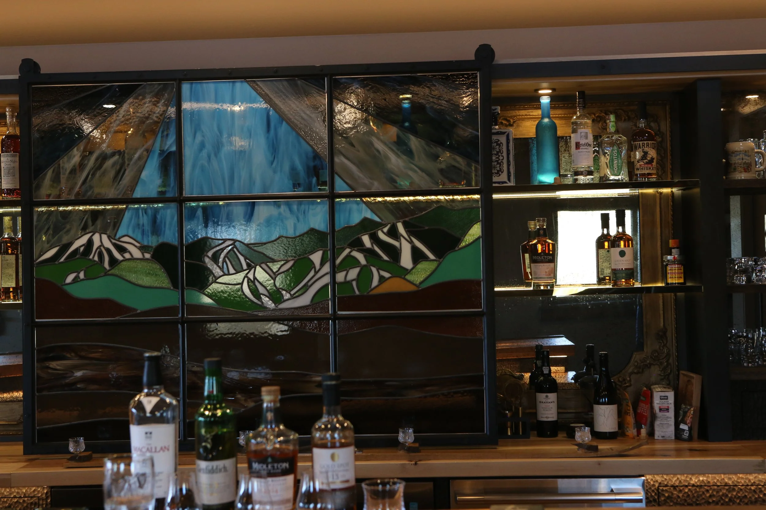 Custom frames made by Brad along with antiqued mirrors to bring the beauty of gold out in the walnut bar and White oak cabinets.