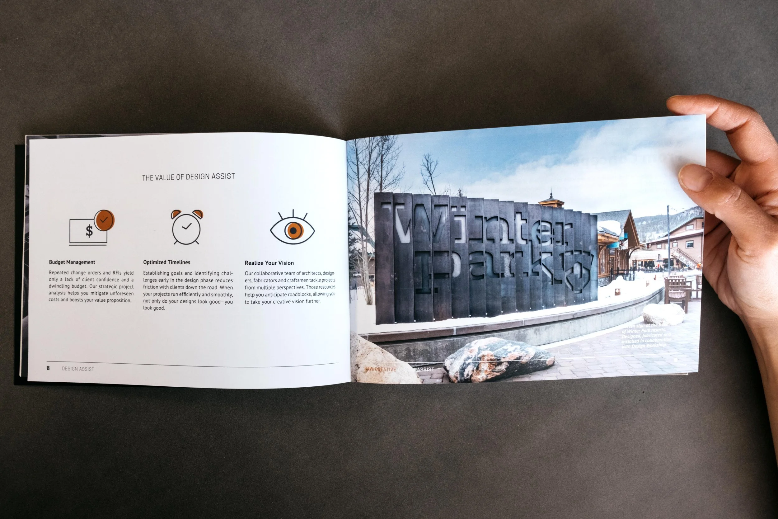 Open booklet showing pages about design assistance with a photo of a Winter Park sign outside buildings in a snowy setting.