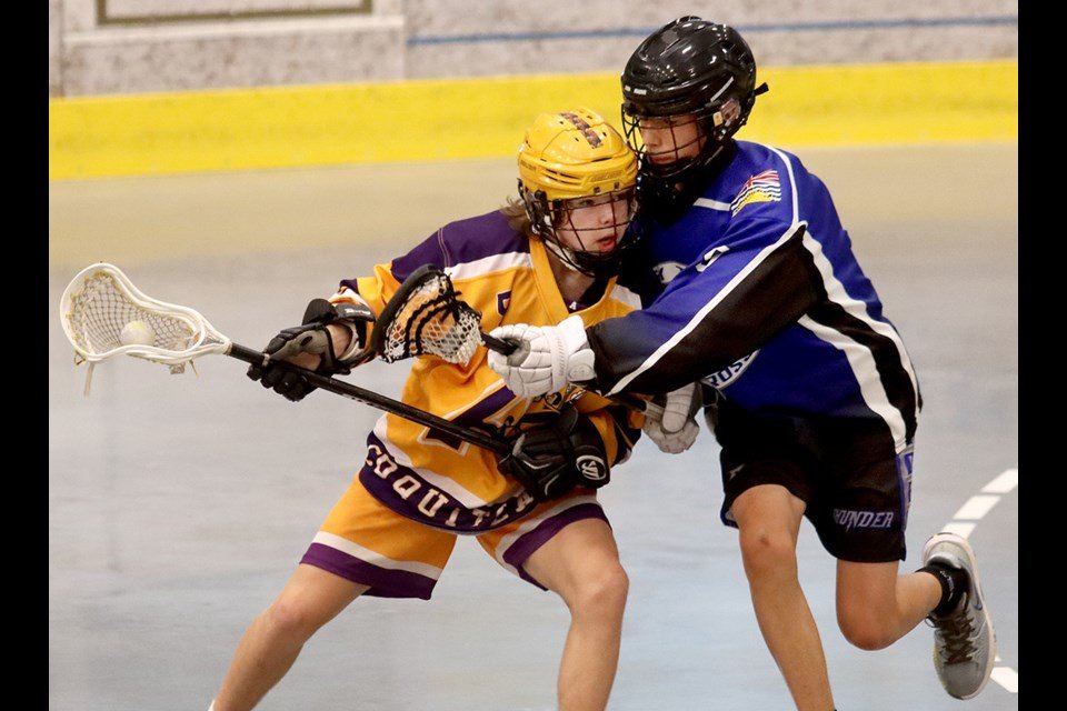  Matty Dane, of the Coquitlam Adanacs, tries to battle his way around a Langley Thunder defender in the first period of their Bantam division game, Friday at the Trevor Wingrove Memorial lacrosse tournament. The tournament continues all weekend at th