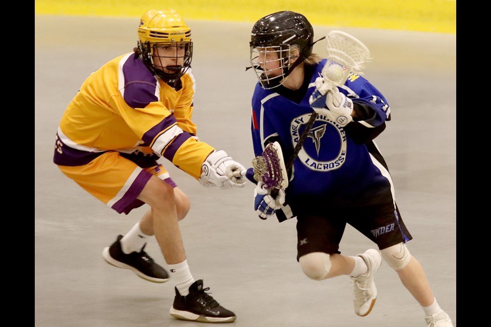  A Langley Thunder forward tries to get past Coquitlam Adanacs defender Alec McNamara in the first period of their Bantam division game at the 37th Trevor Wingrove Memorial lacrosse tournament, Friday at the Poirier Sport and Leisure Complex. | MARIO