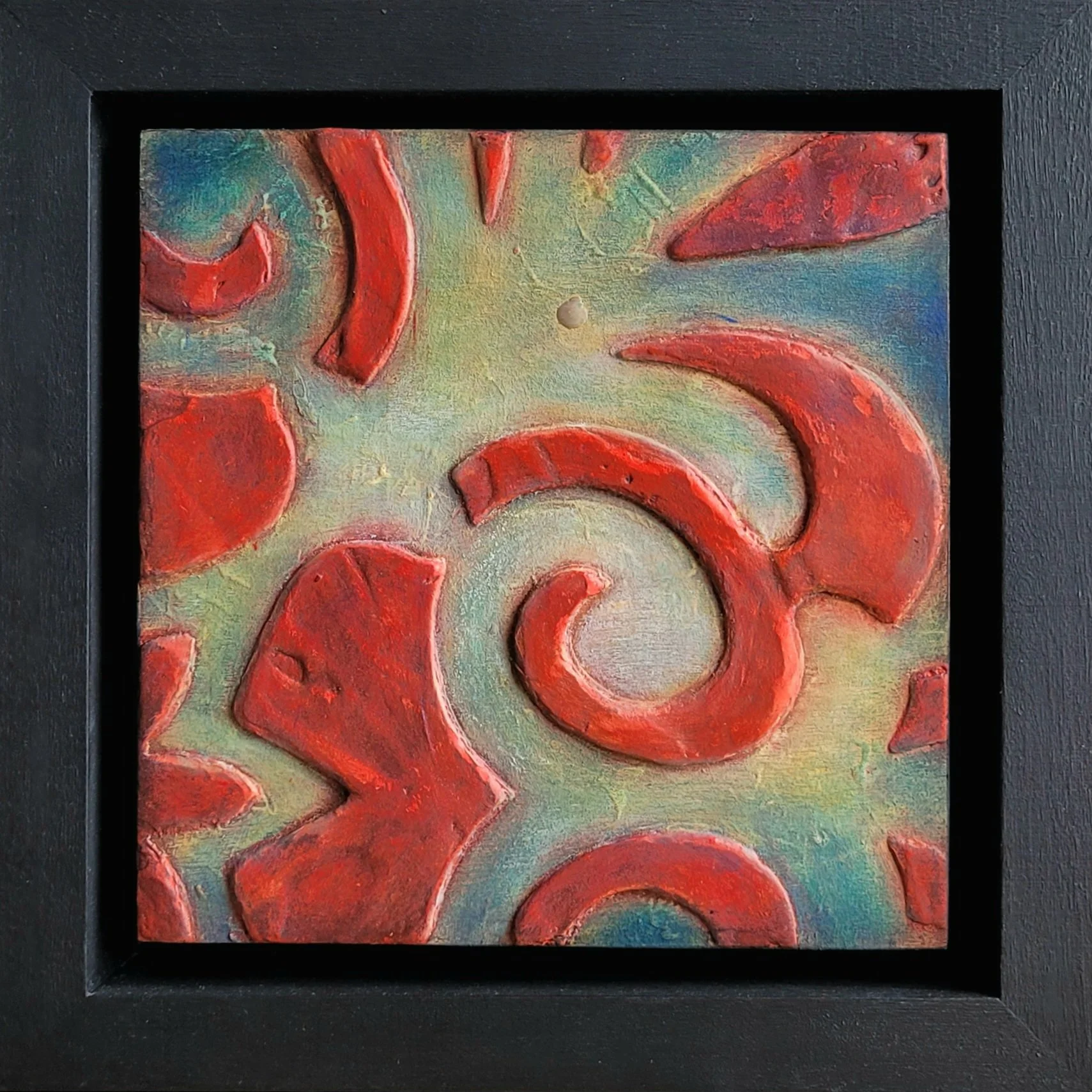 Carnival by Dee Hutton, shown in its black frame. This 6x6 inch encaustic mixed media piece features bright red raised designs on a textured ground of white, yellow and blue.