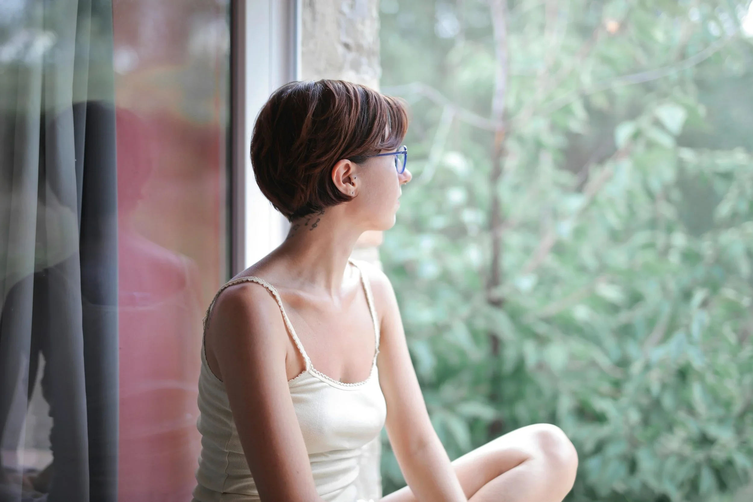 Woman looking thoughtfully out a window.