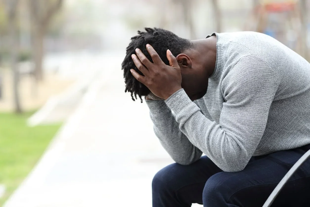 Man sitting with his head in his hands during a moment of overwhelm.