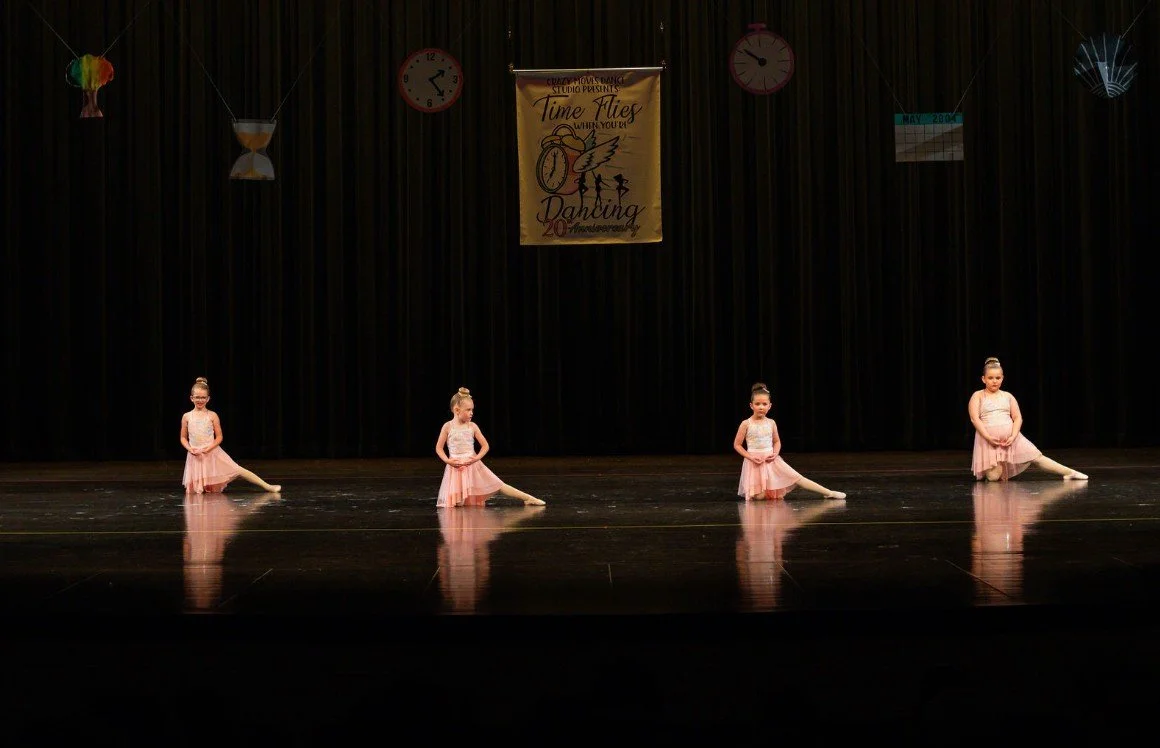 Group of young dancers performing a synchronized routine on stage at a Crazy Moves Dance recital, dressed in sparkly black and gold outfits..jpg