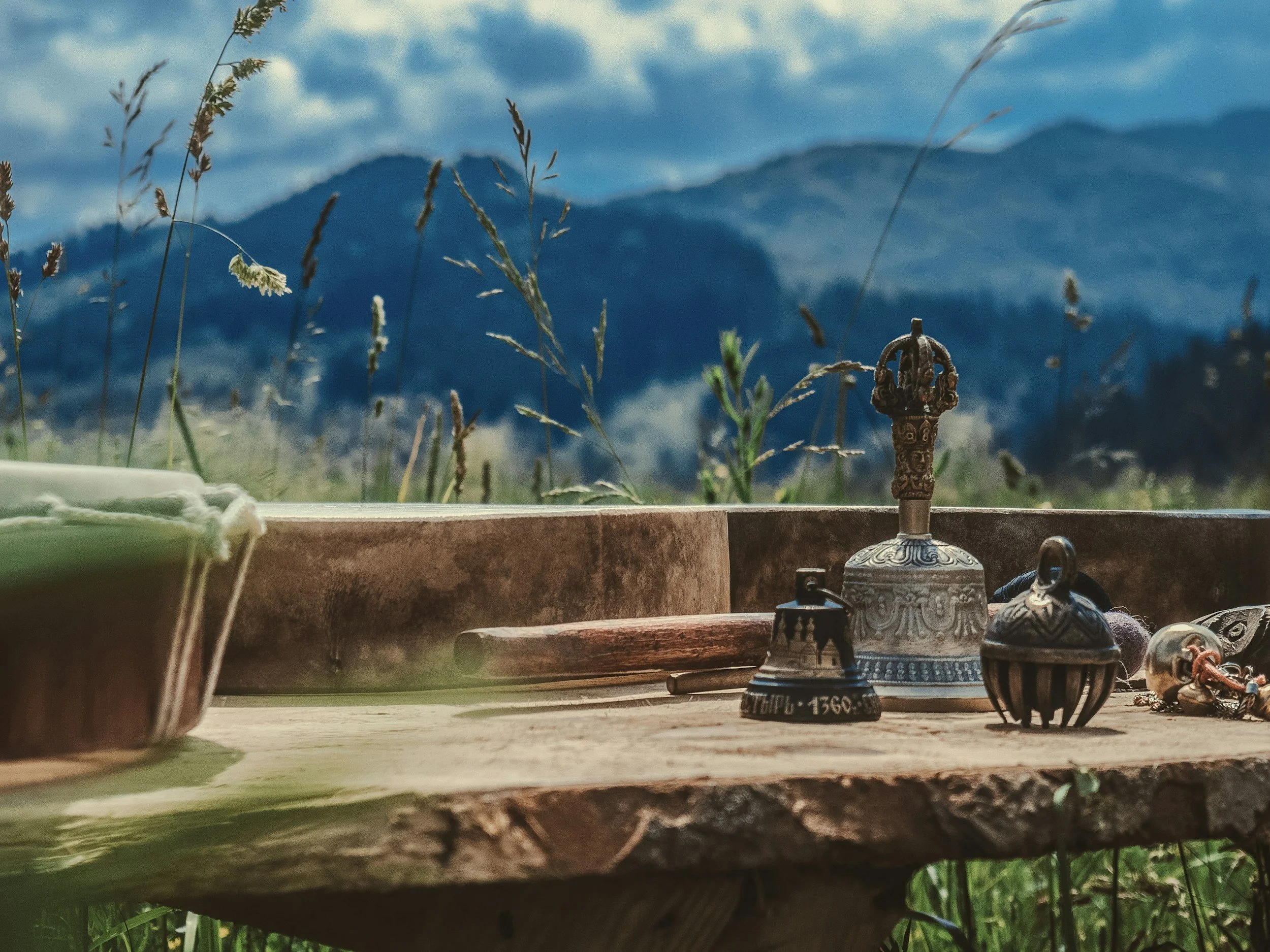 wooden table with tibetan bells and mountains blurred in background