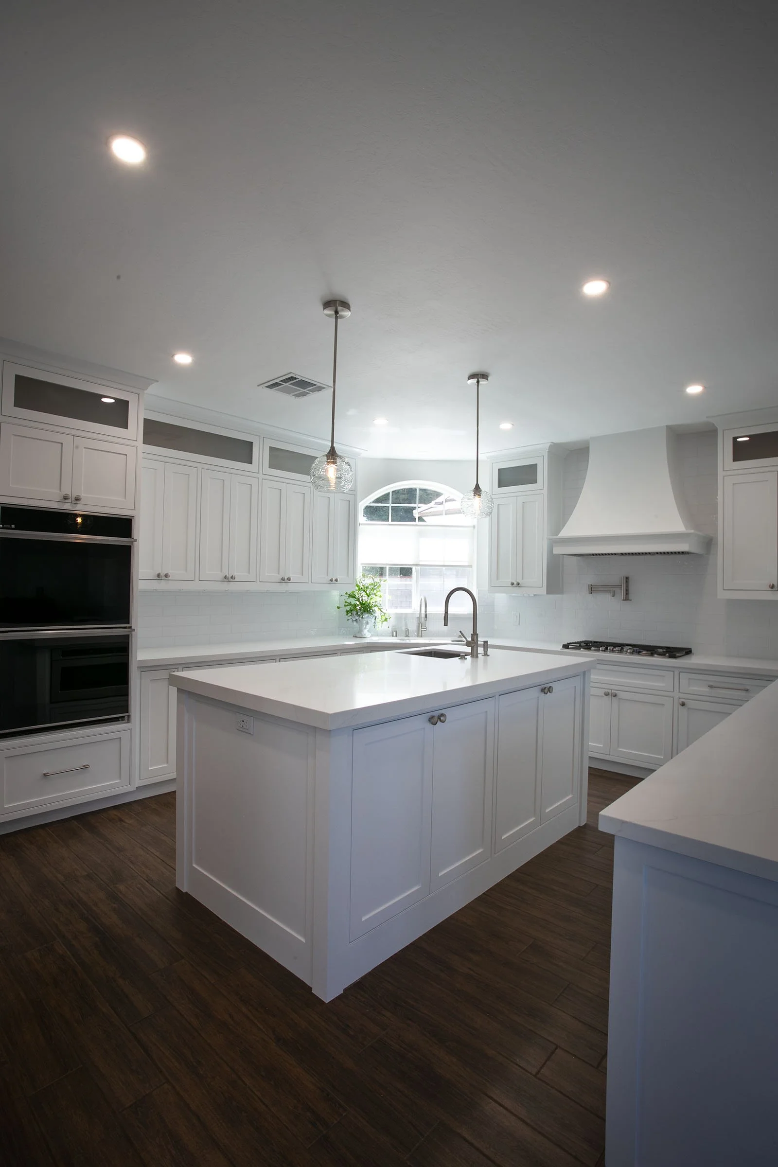 Custom kitchen with white cabinets, large island, pendant lighting, and recessed lights in Tehachapi, California