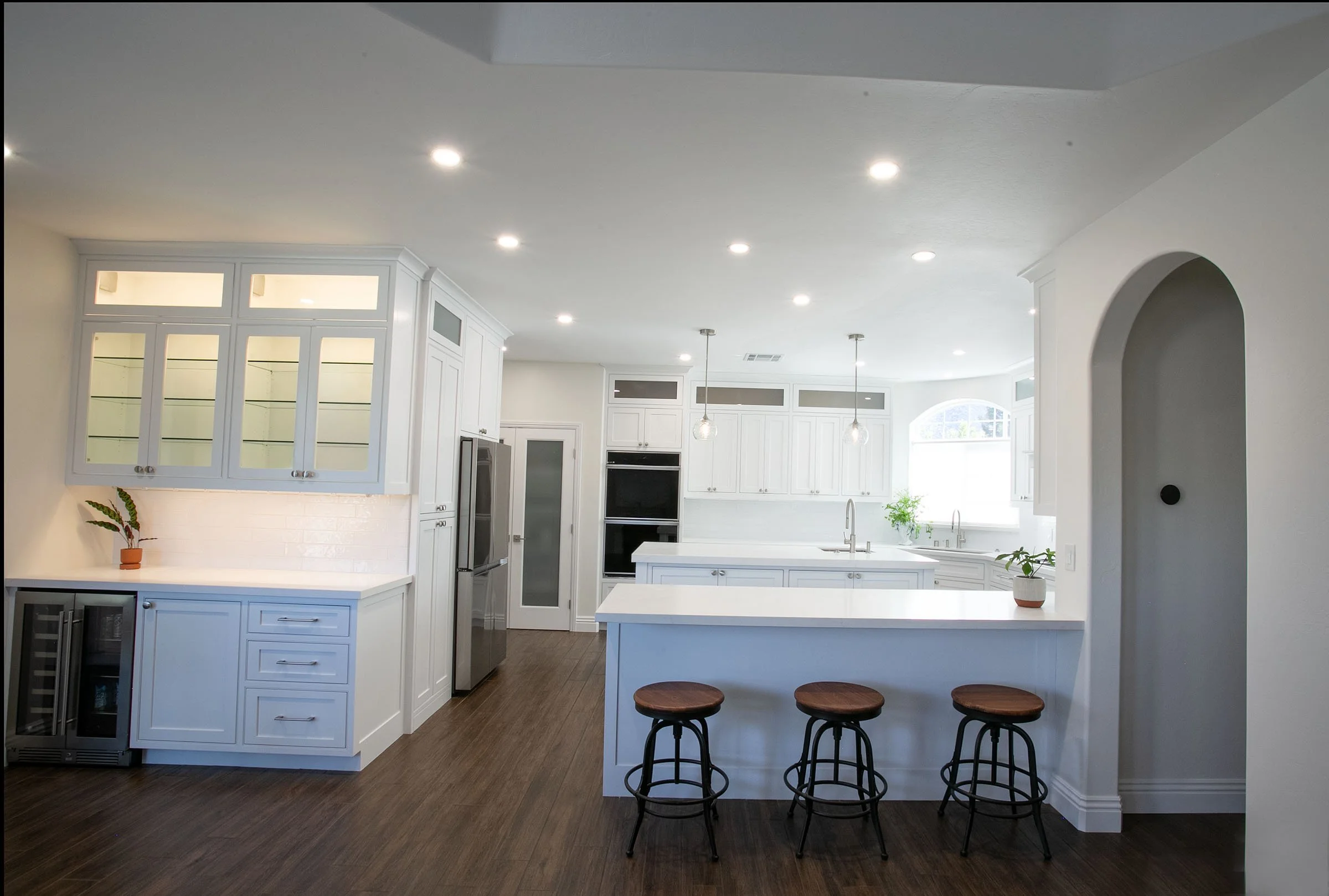 Open concept kitchen with white shaker cabinets, large island seating, and custom cabinetry in Tehachapi, California