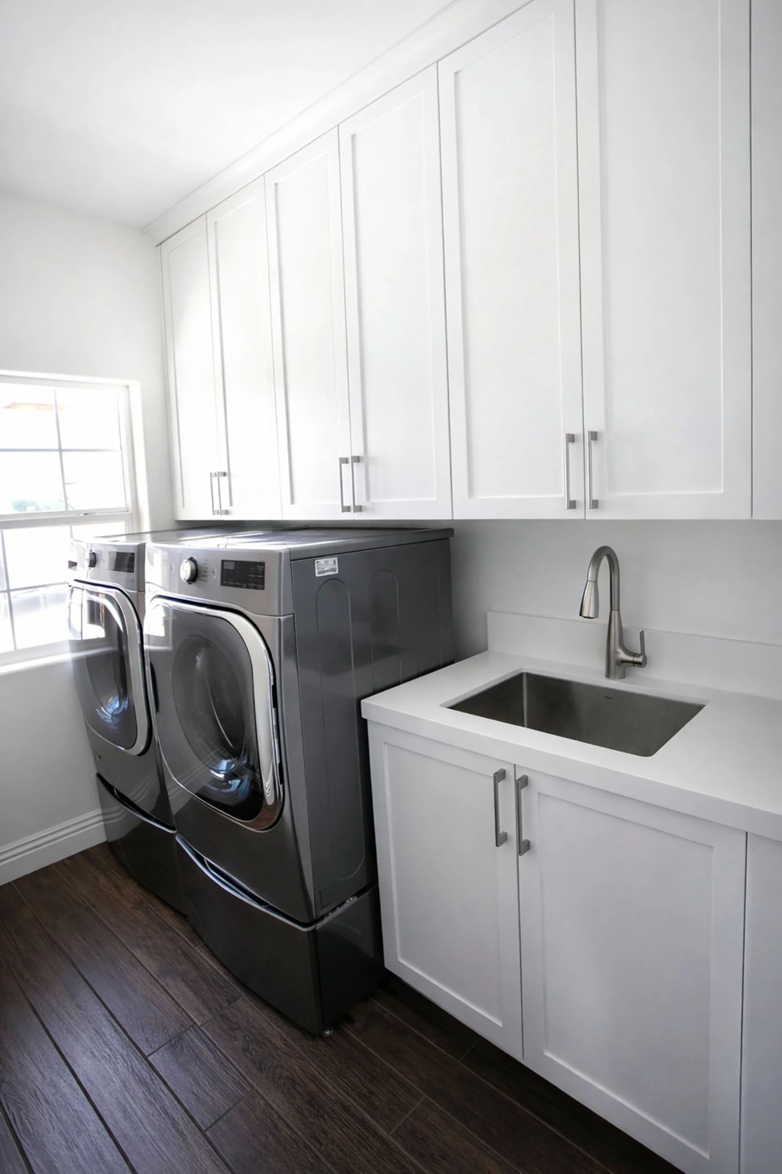 Custom laundry room cabinets with storage, utility sink, and white shaker cabinetry in Tehachapi, California