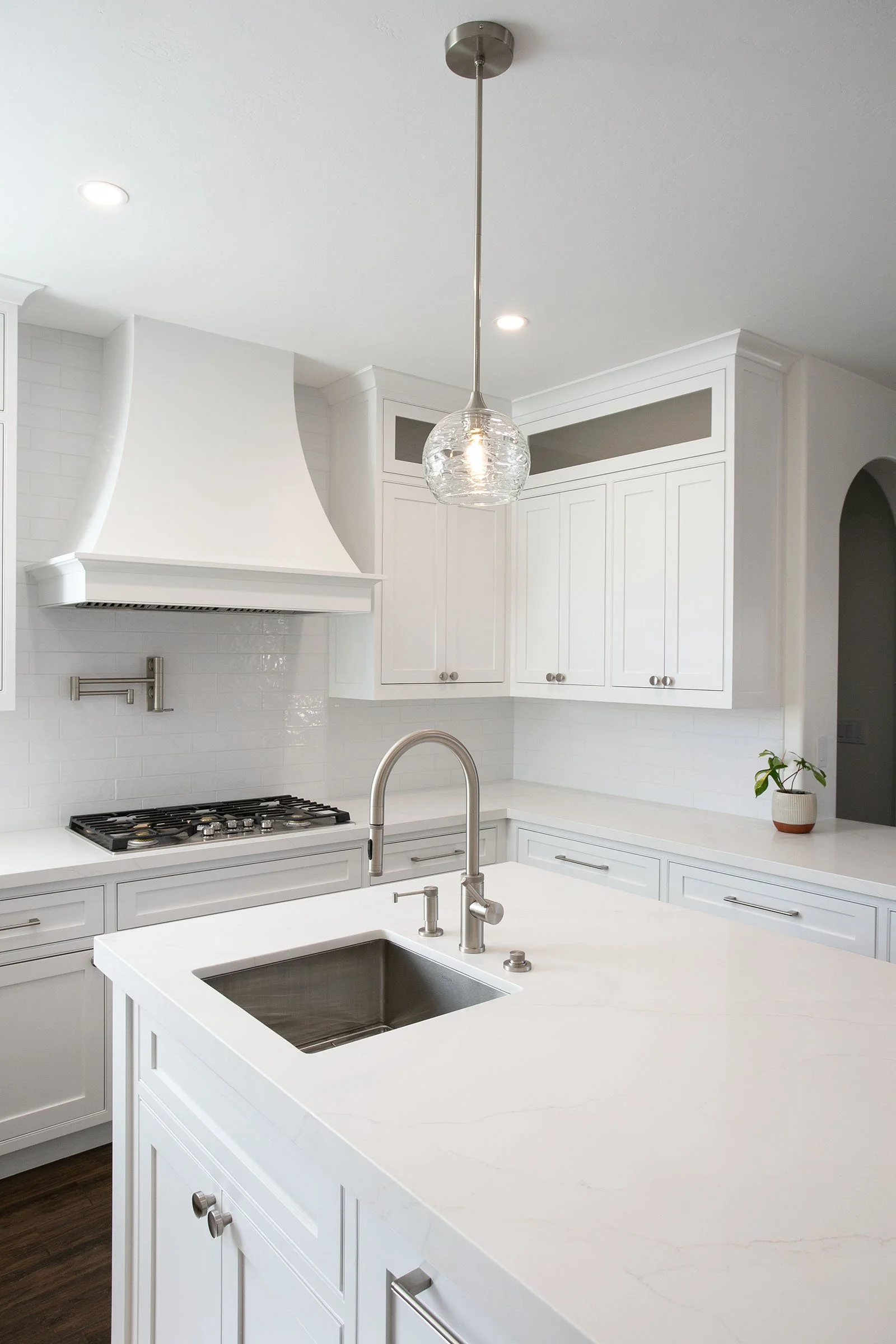 Custom kitchen island with sink, modern faucet, quartz countertops, and white shaker cabinets in Tehachapi, California