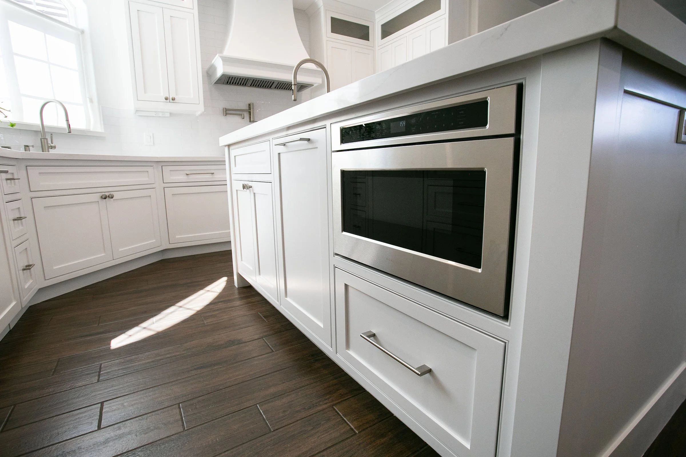 Custom kitchen island with built-in oven, white shaker drawer cabinets, and quartz countertops in Tehachapi, California