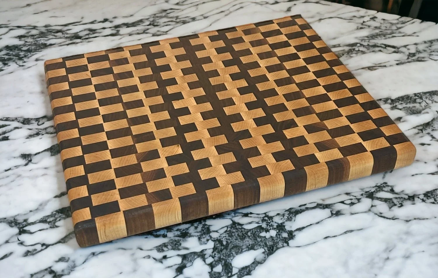 Intricate wooden cutting board with a geometric pattern, placed on a marble surface.