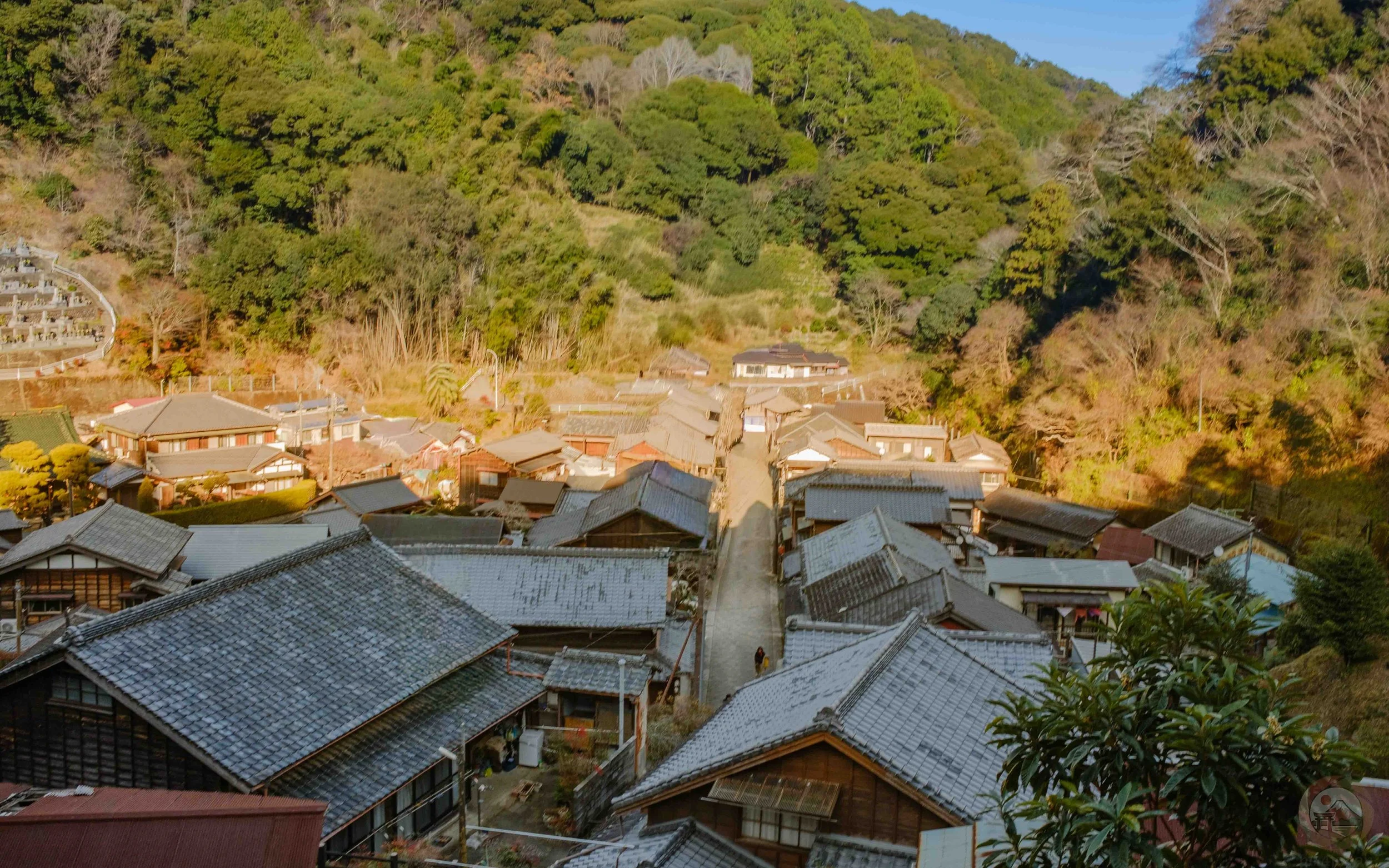 A hillside view of tiled rooftops and a narrow road running through the historic hamlet of Utsunoya in Shizuoka, Japan.