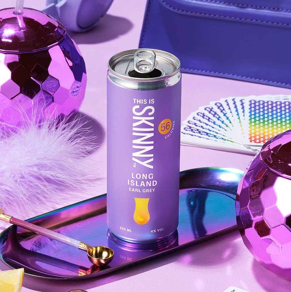 Canned long island iced tea by This Is Skinny with Earl Grey flavouring in a purple can surrounded by party items