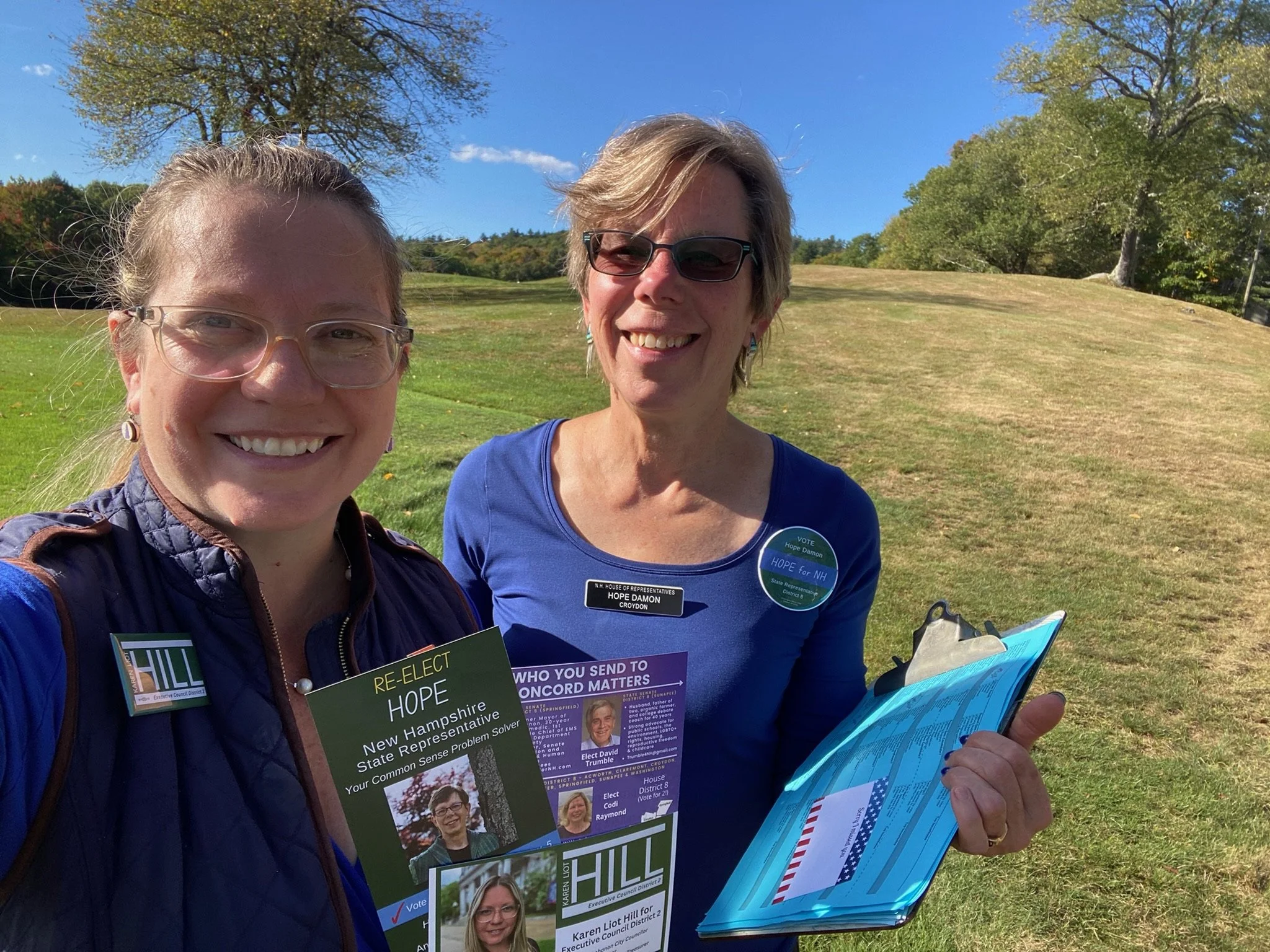 Hope and a volunteer in a field with literature