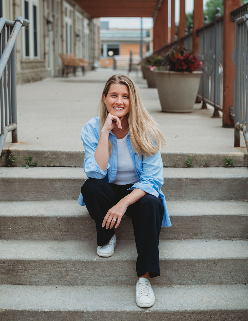 Carley Rollins, licensed nutritionist and board-certified health coach, seated on outdoor steps.