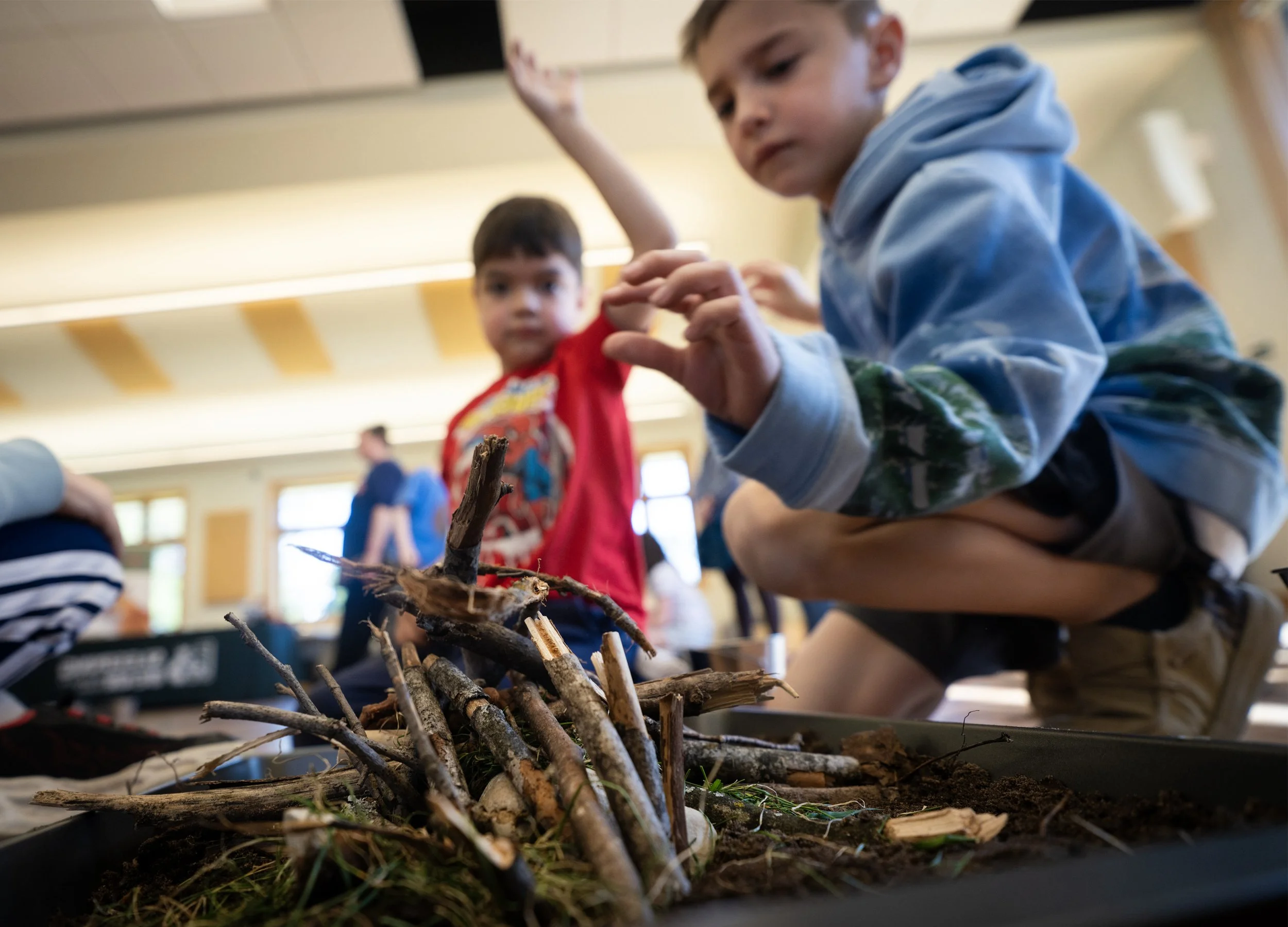 Two young boys are focused on a building a beaver dam. This is an activity that helps kids understand how beavers are like engineers. A great STEM activity for kids!