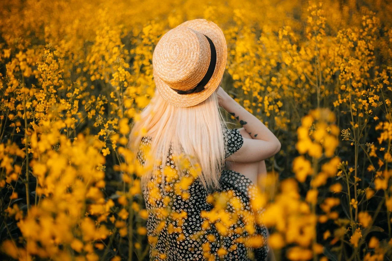 a female writer sitting in a summer flower field