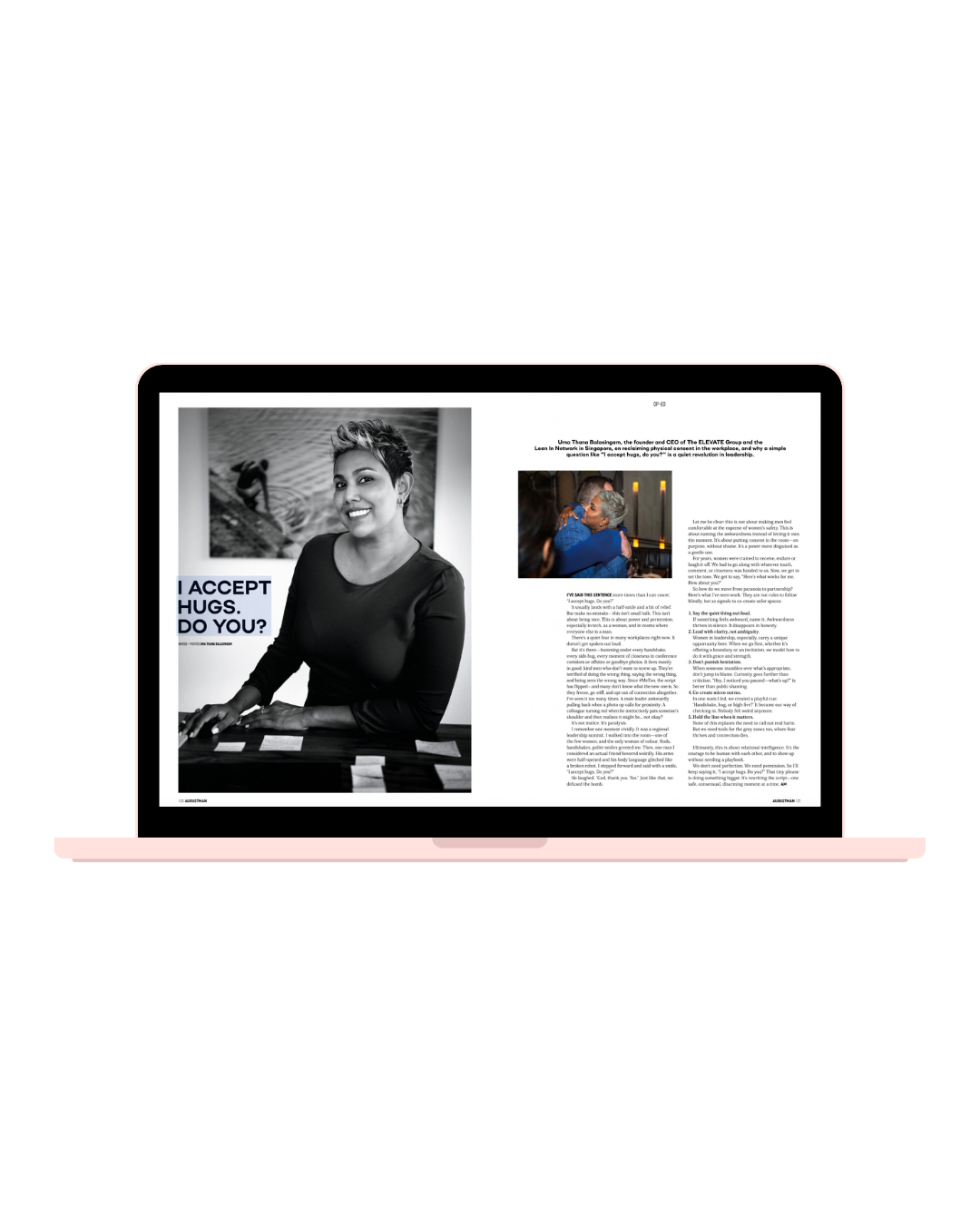 A pink laptop displaying a magazine spread with a black and white photo of a smiling woman, and an article. The page features a bold headline asking, 'I ACCEPT HUGS. DO YOU?', and includes a small color photo of two people hugging, alongside text.