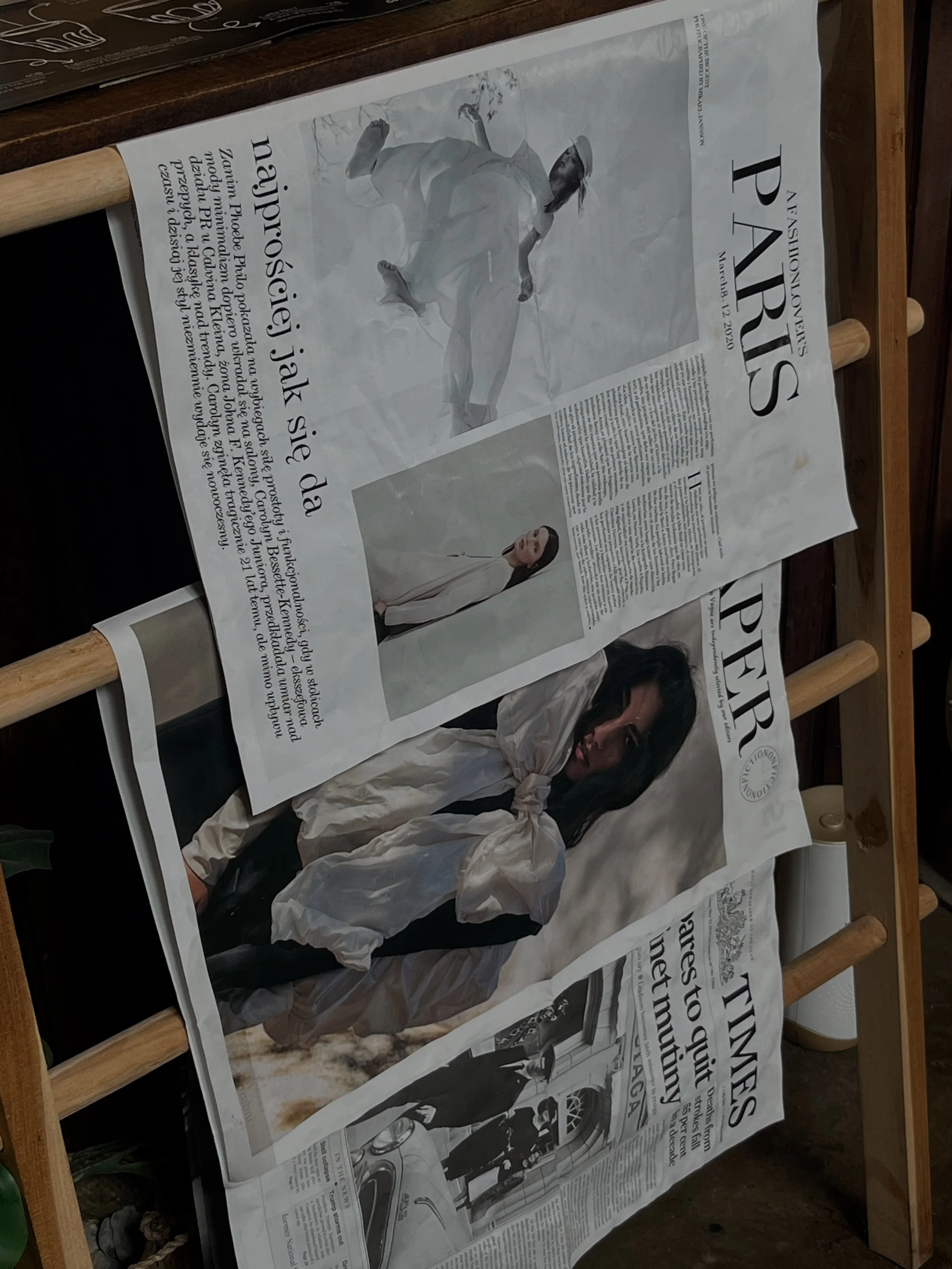 A newspaper page on a wooden table, displaying multiple articles, pictures of women, some wearing white coats, with texts in a language that appears to be Hungarian.