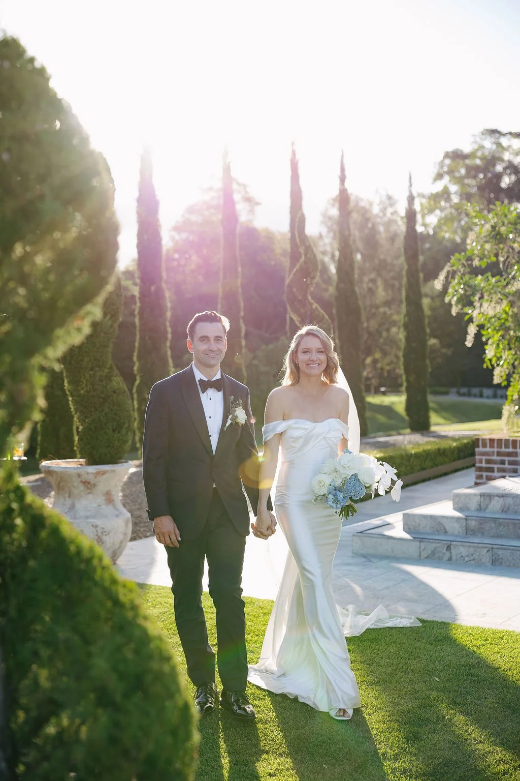 Newlyweds walking hand in hand through the grounds