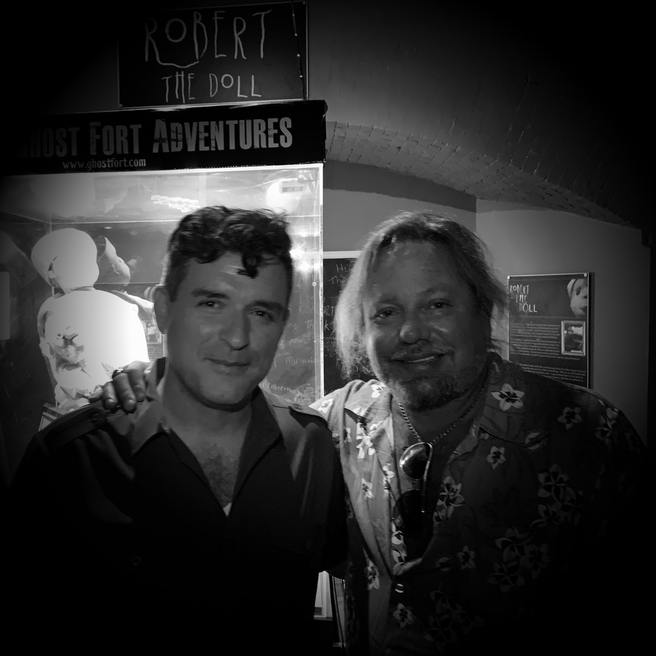 Paranormal expert David Sloan and Motley Crue rock star Vince Neil smile inside Key West's Fort East Martello Museum with Robert the Doll. 