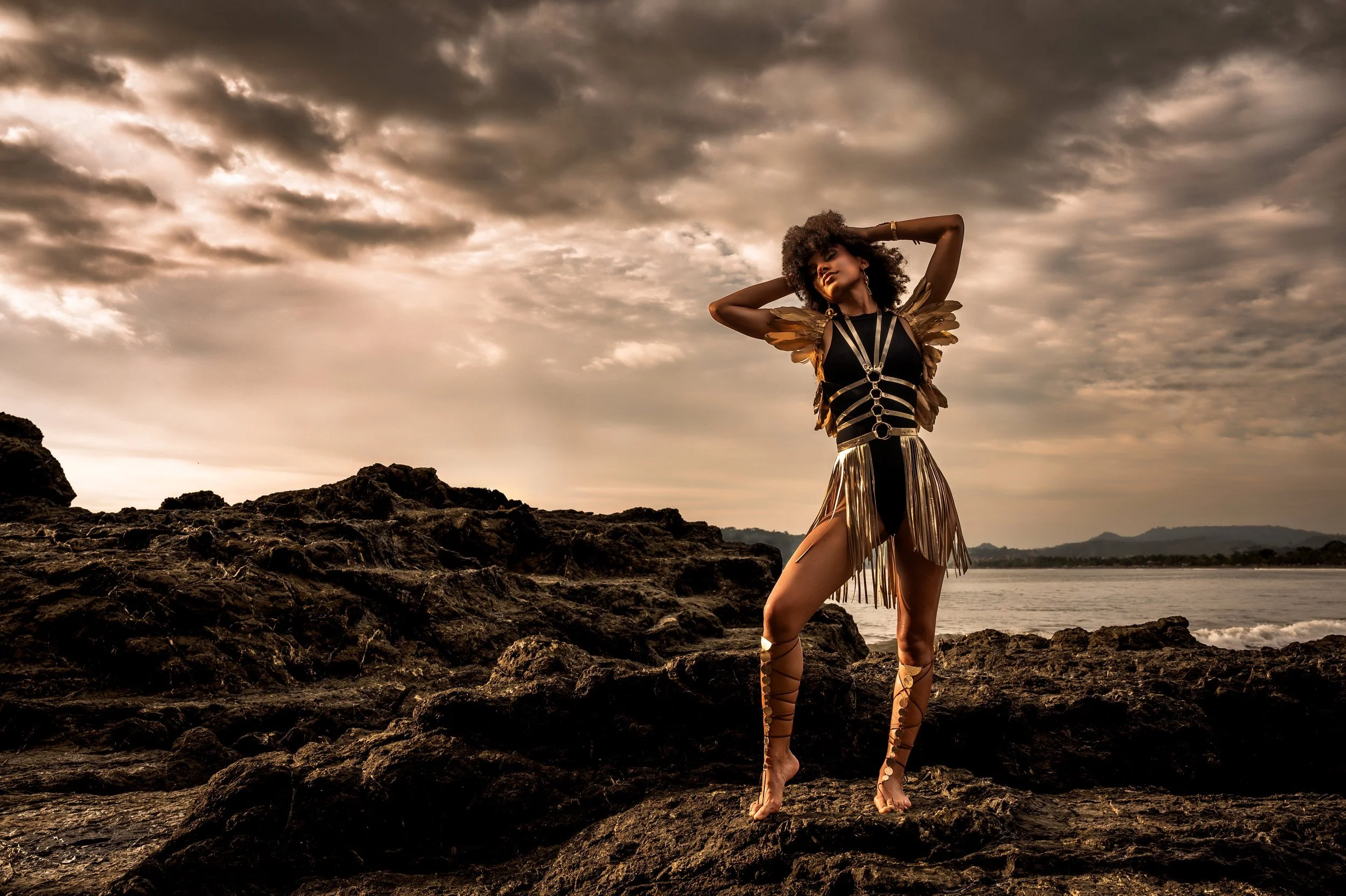 a beautiful black woman stands on the coast for a sunlit portrait, Erie PA rocky shores