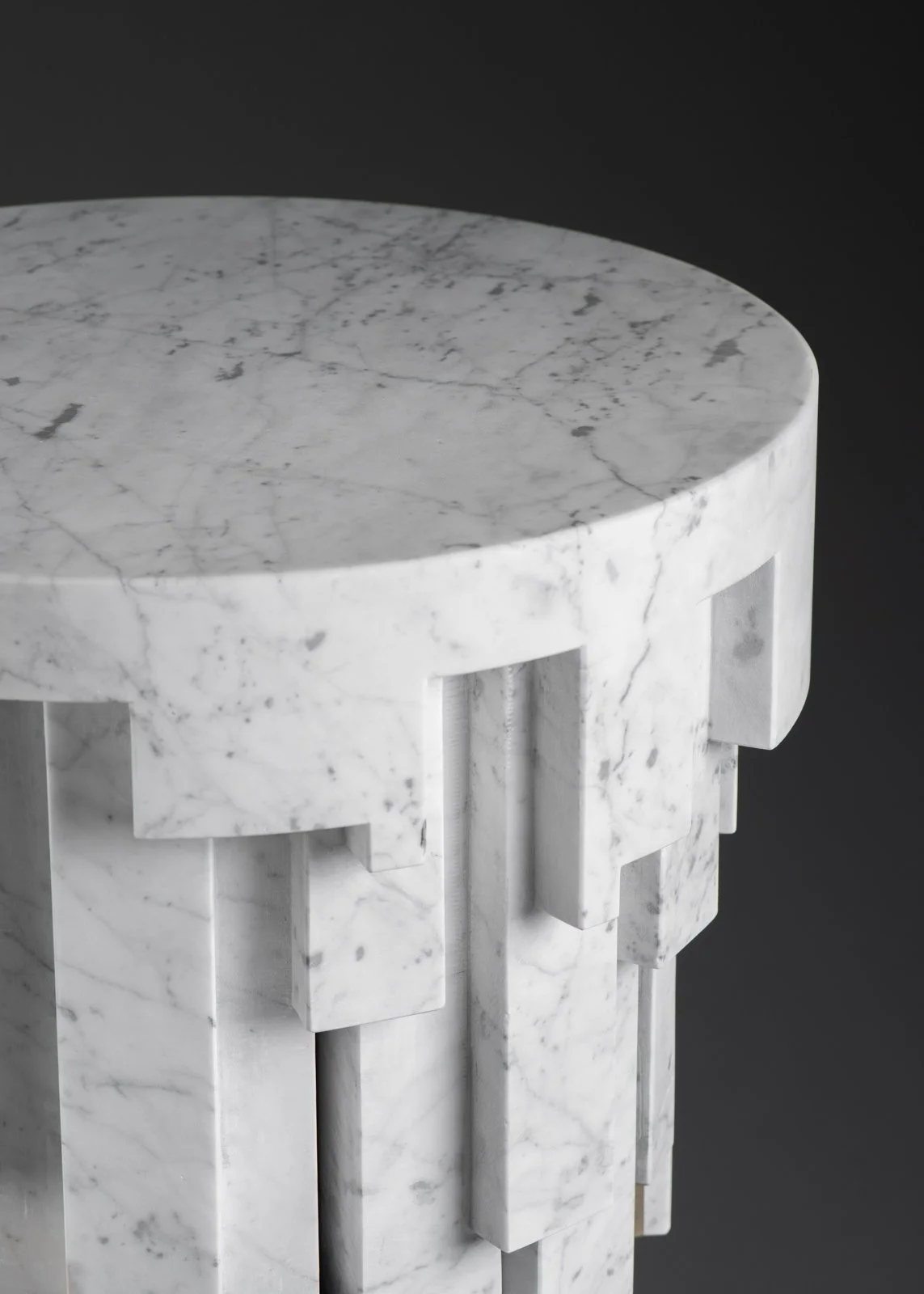 Table ronde en marbre blanc avec un motif veiné gris, vue de dessus.