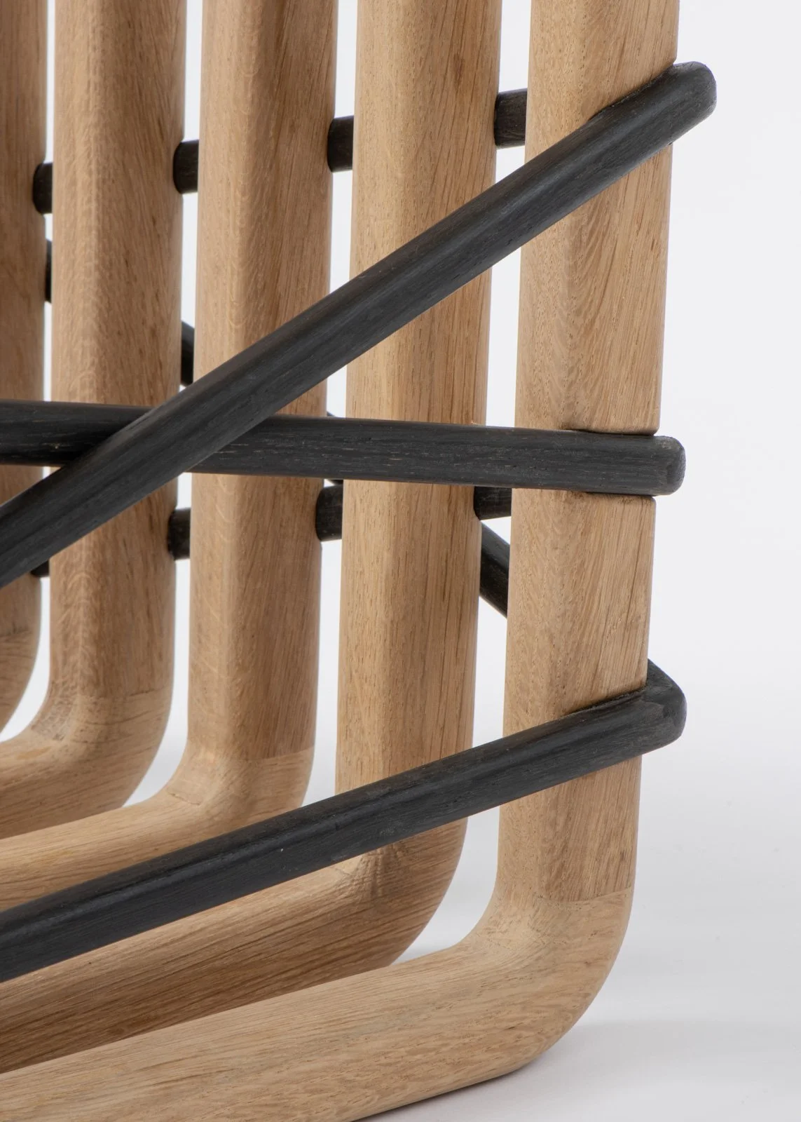 Vue rapprochée d'une structure en bois avec des barres horizontales noires en métal ou en bois peint noir.