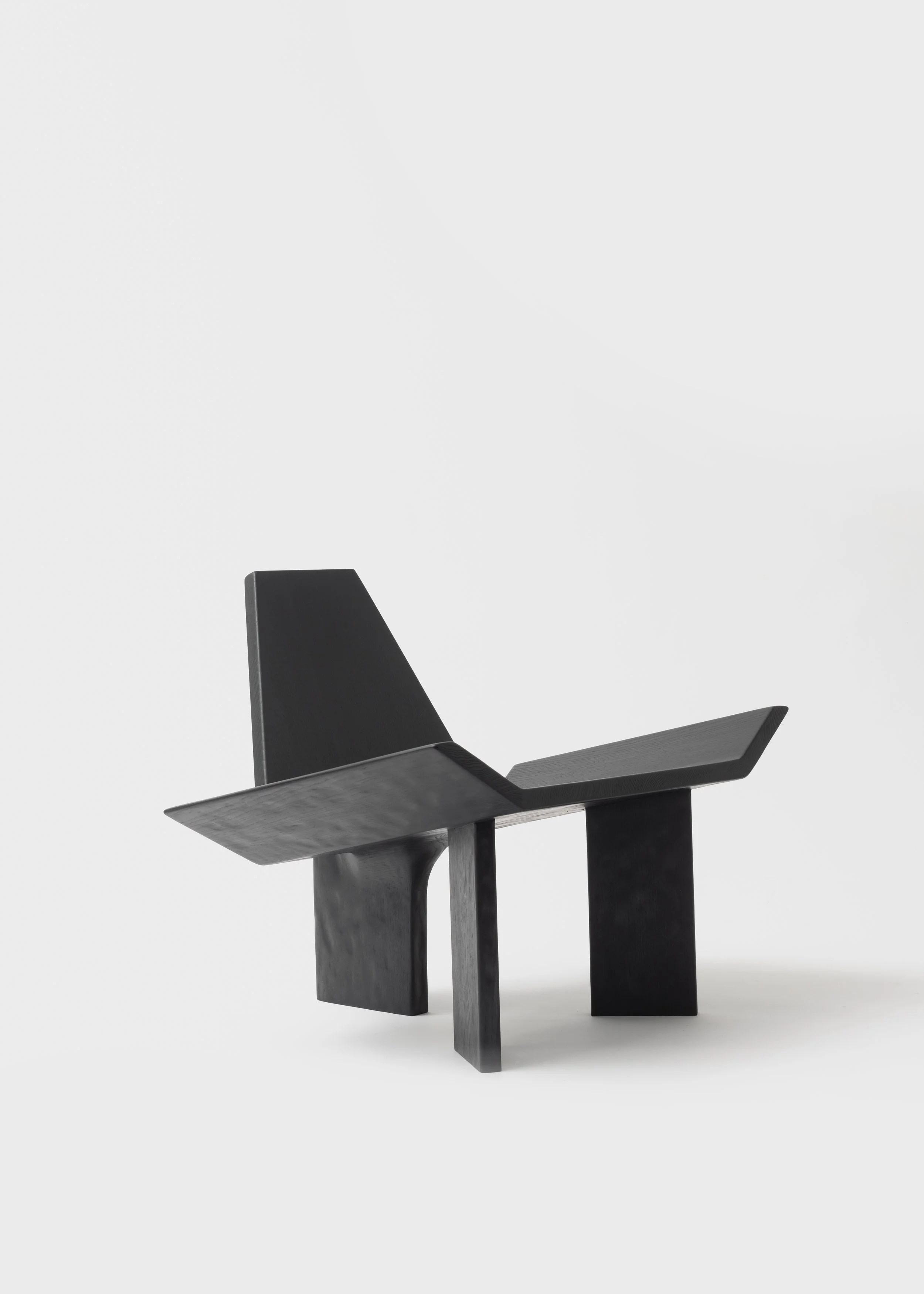Une chaise de design moderne, en bois noir, avec une forme géométrique unique, sur un fond blanc.