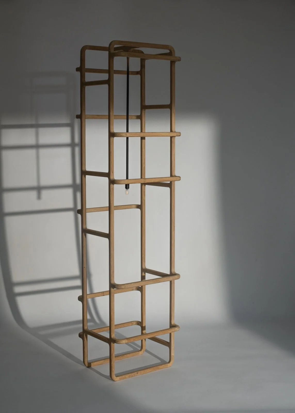 Une étagère en bois de forme géométrique avec une ombre projetée sur un mur