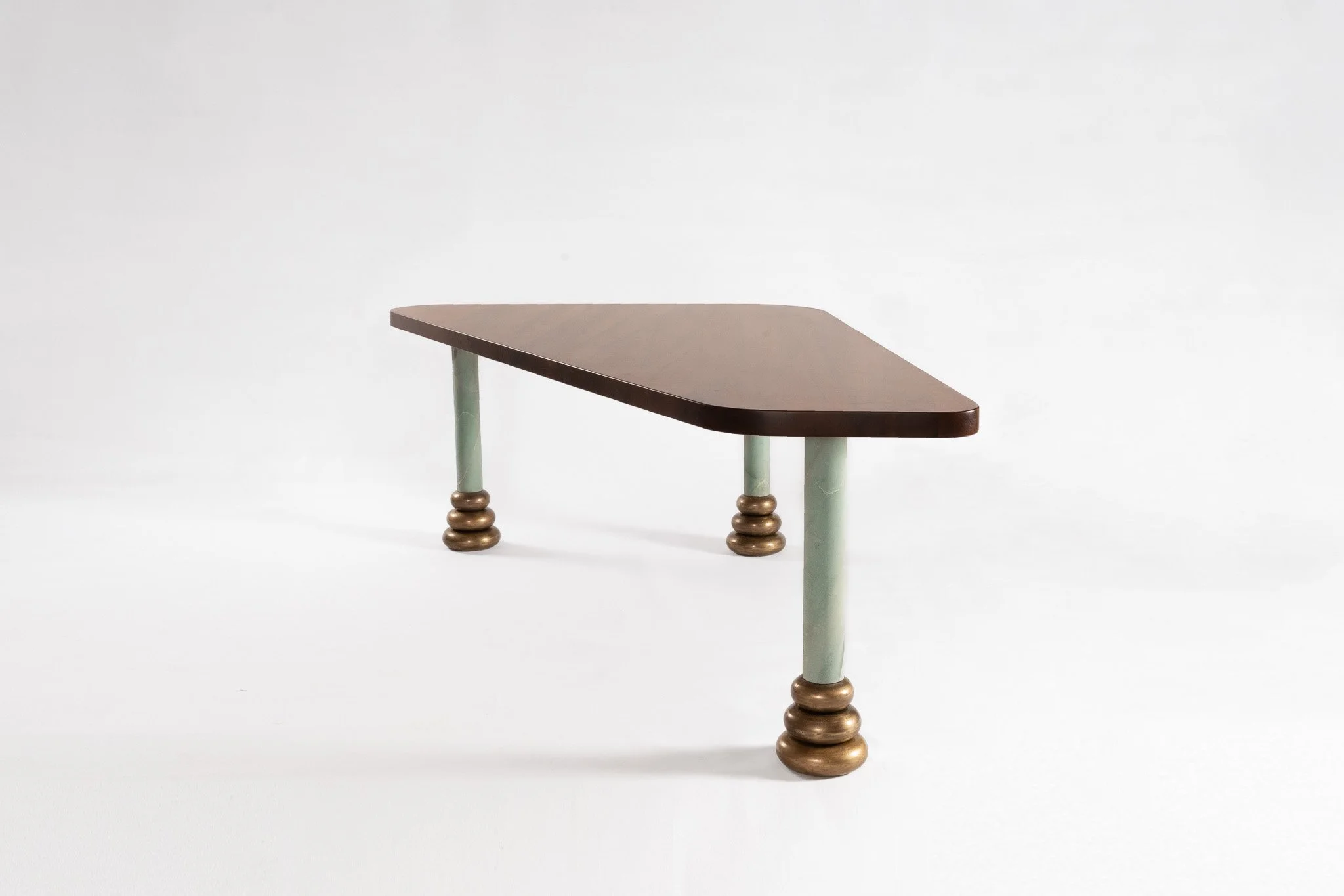Table en bois avec des pieds en forme de cercles superposés, sur fond blanc.