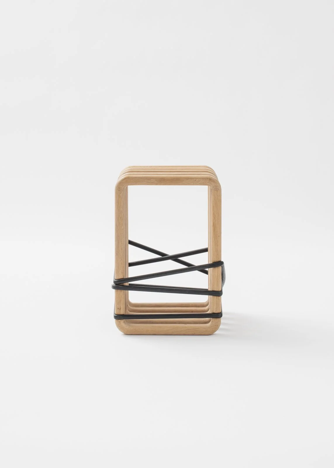 Chaise en bois avec une structure en métal noir, empilée dans un design minimaliste.
