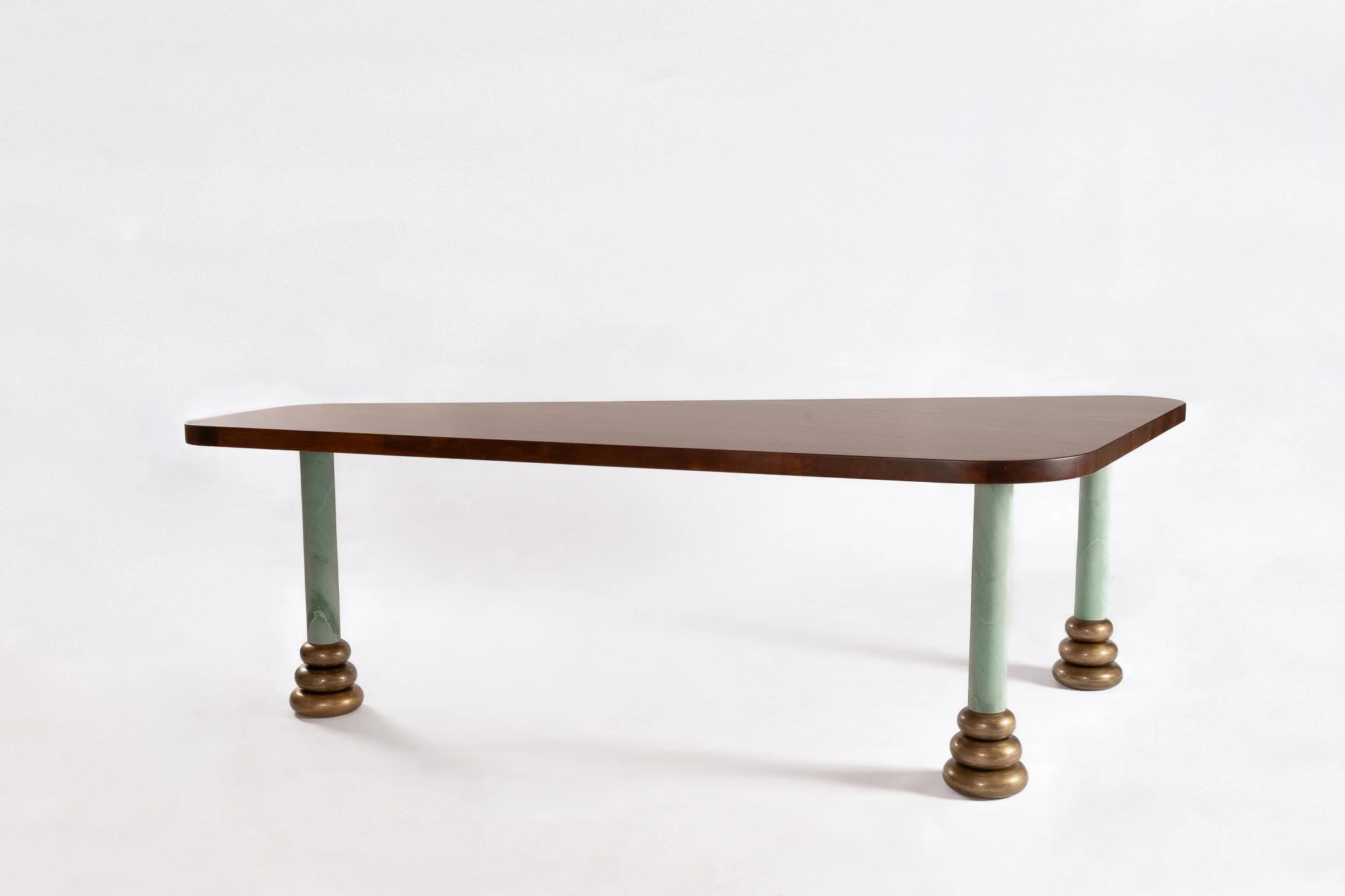 Table en bois avec quatre pieds distincts, deux en bois arrondi et deux en bois avec une finition verte, sur fond blanc.
