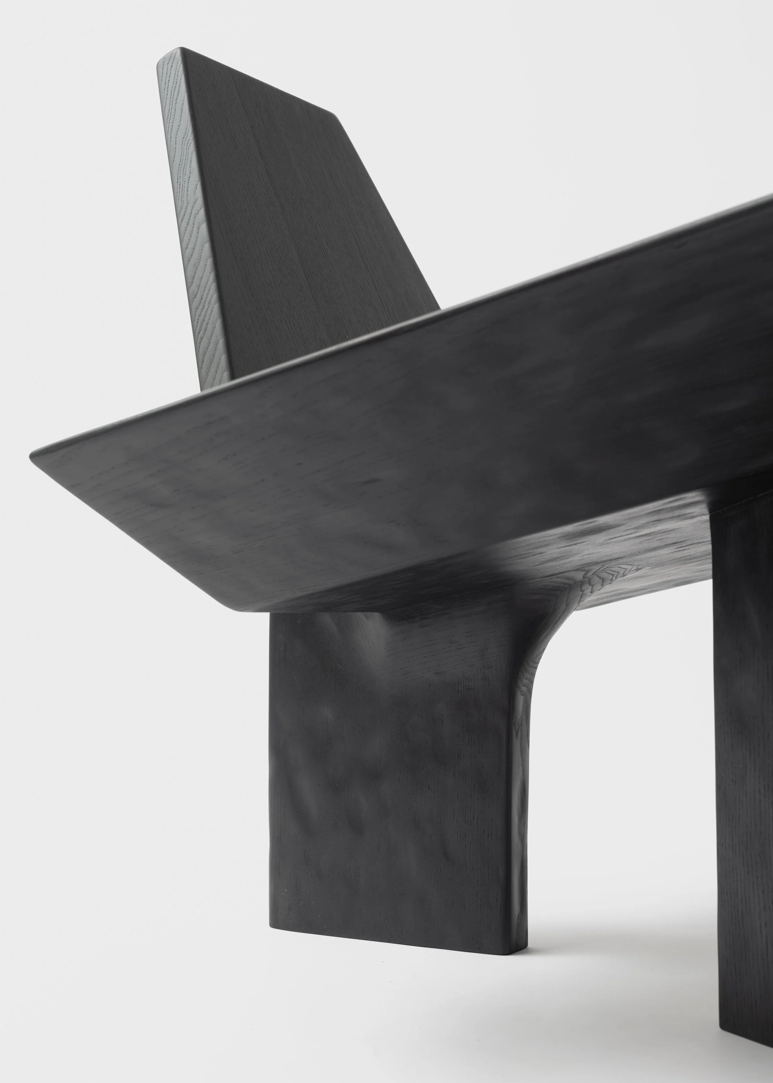 Meuble en bois noir avec un plateau épais et une structure en bois massif, vue en angle