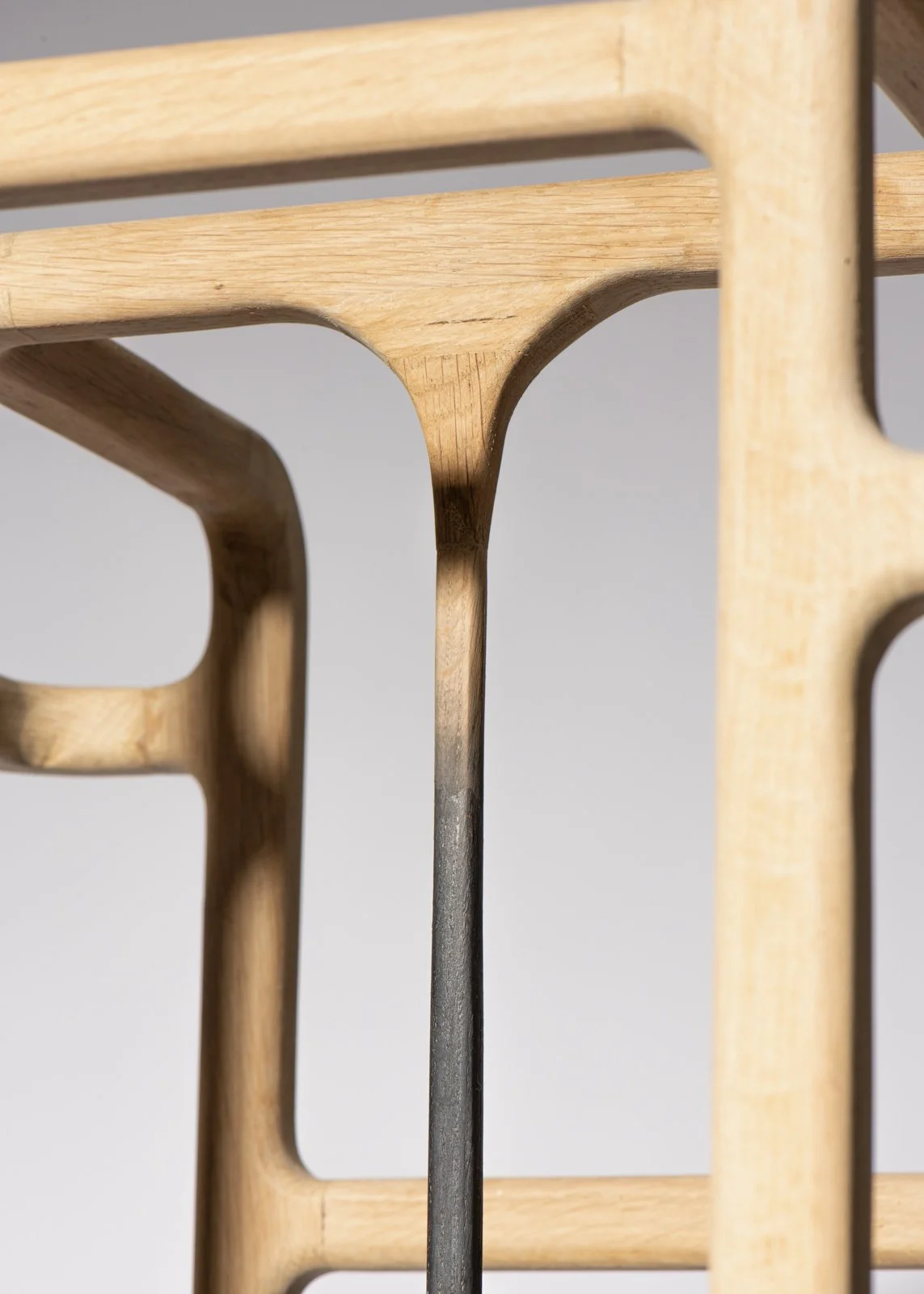 Gros plan d'une structure en bois et métal, avec decoupes rectangulaires et courbes.
