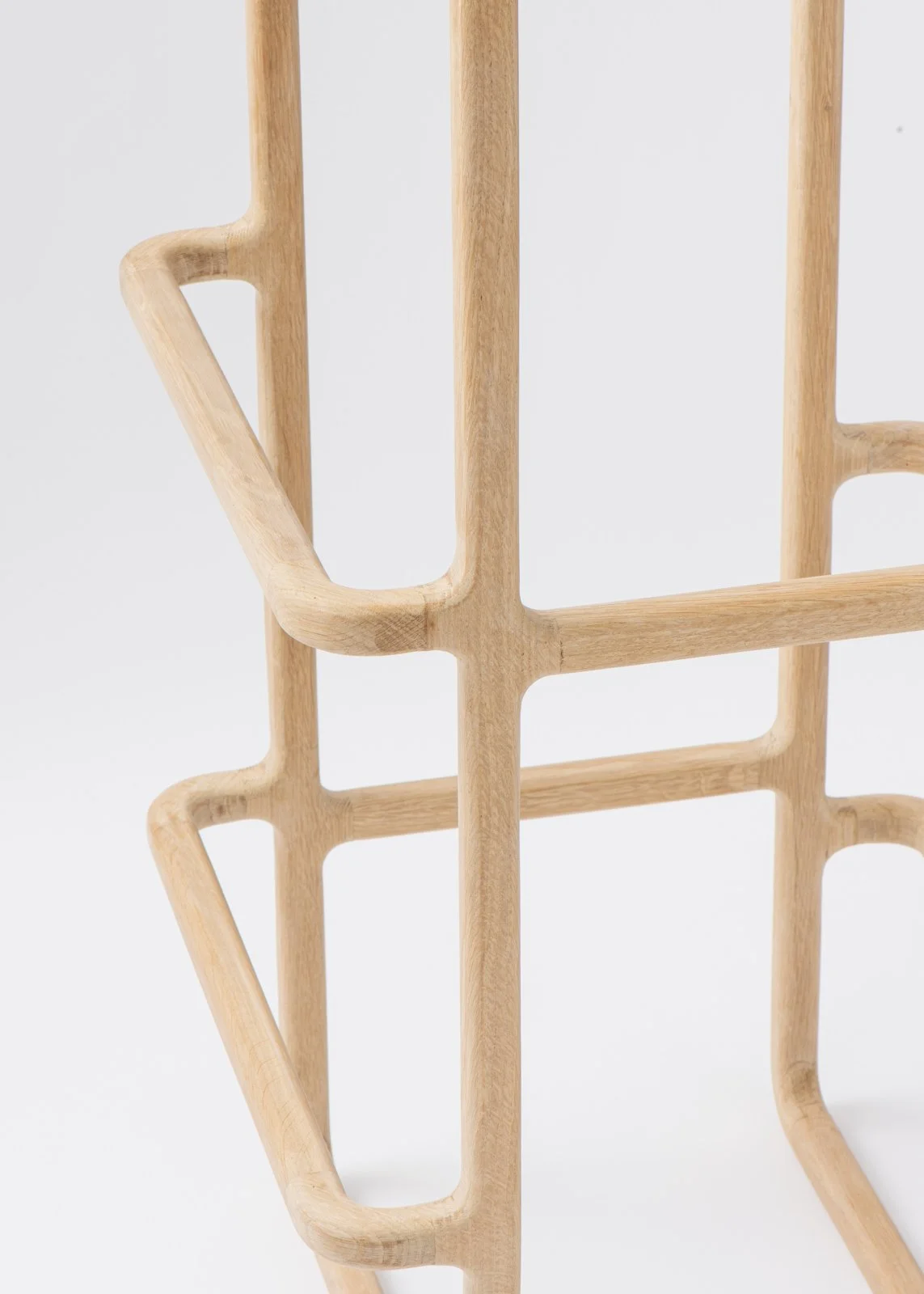 Structure en bois avec plusieurs formes géométriques, principalement rectangulaires et courbes, avec un fond blanc.