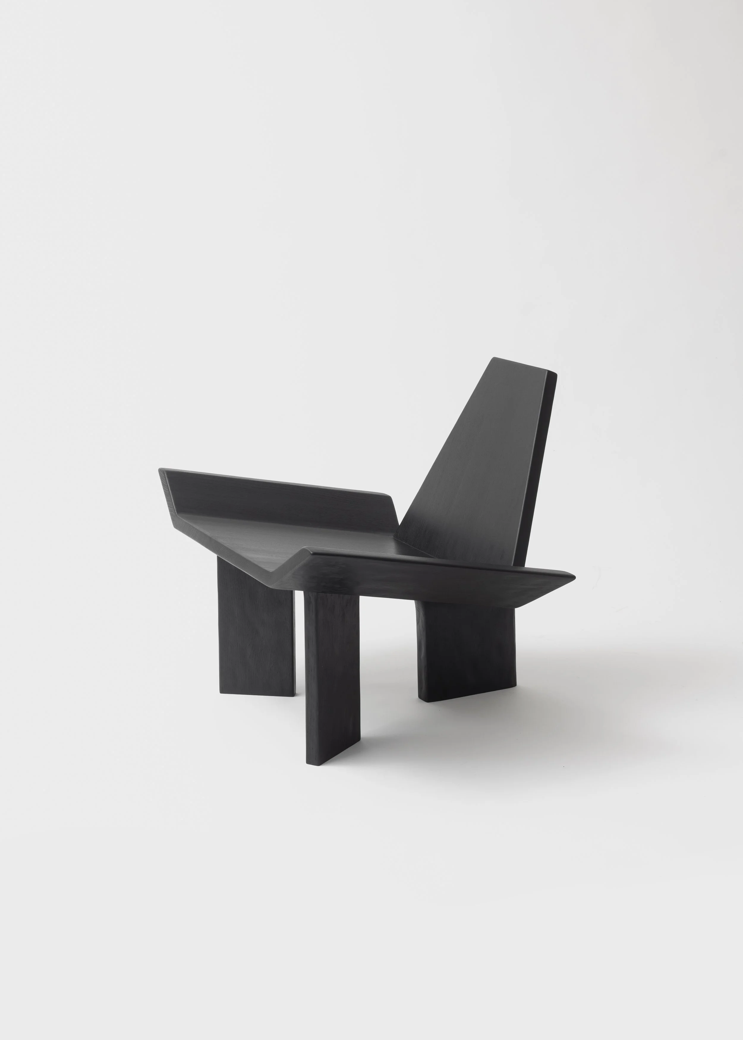 Une chaise en bois noire au design moderne, avec un dossier droit, placée sur un fond blanc.