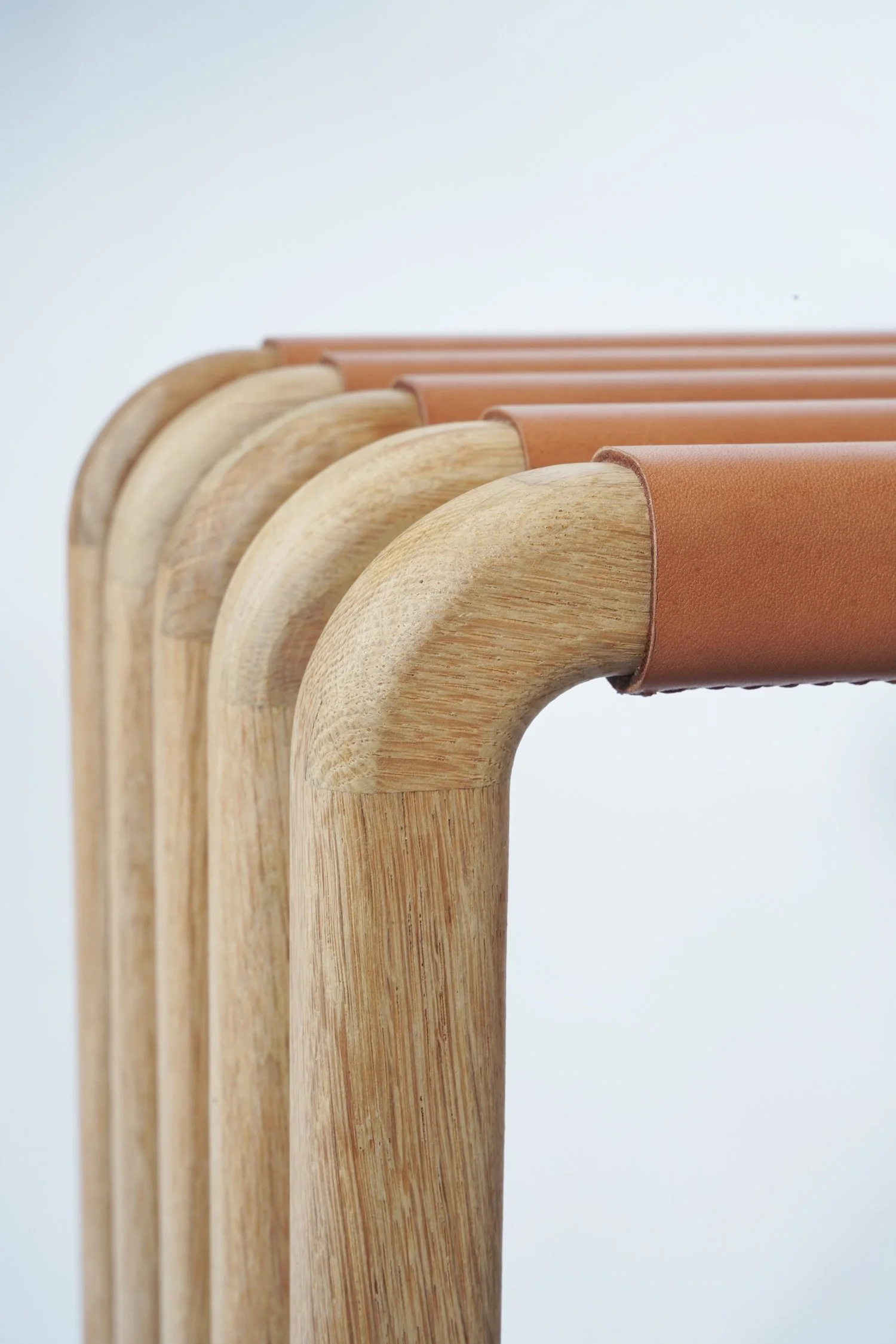 Gamme de cintres en bois avec doublure en cuir brun