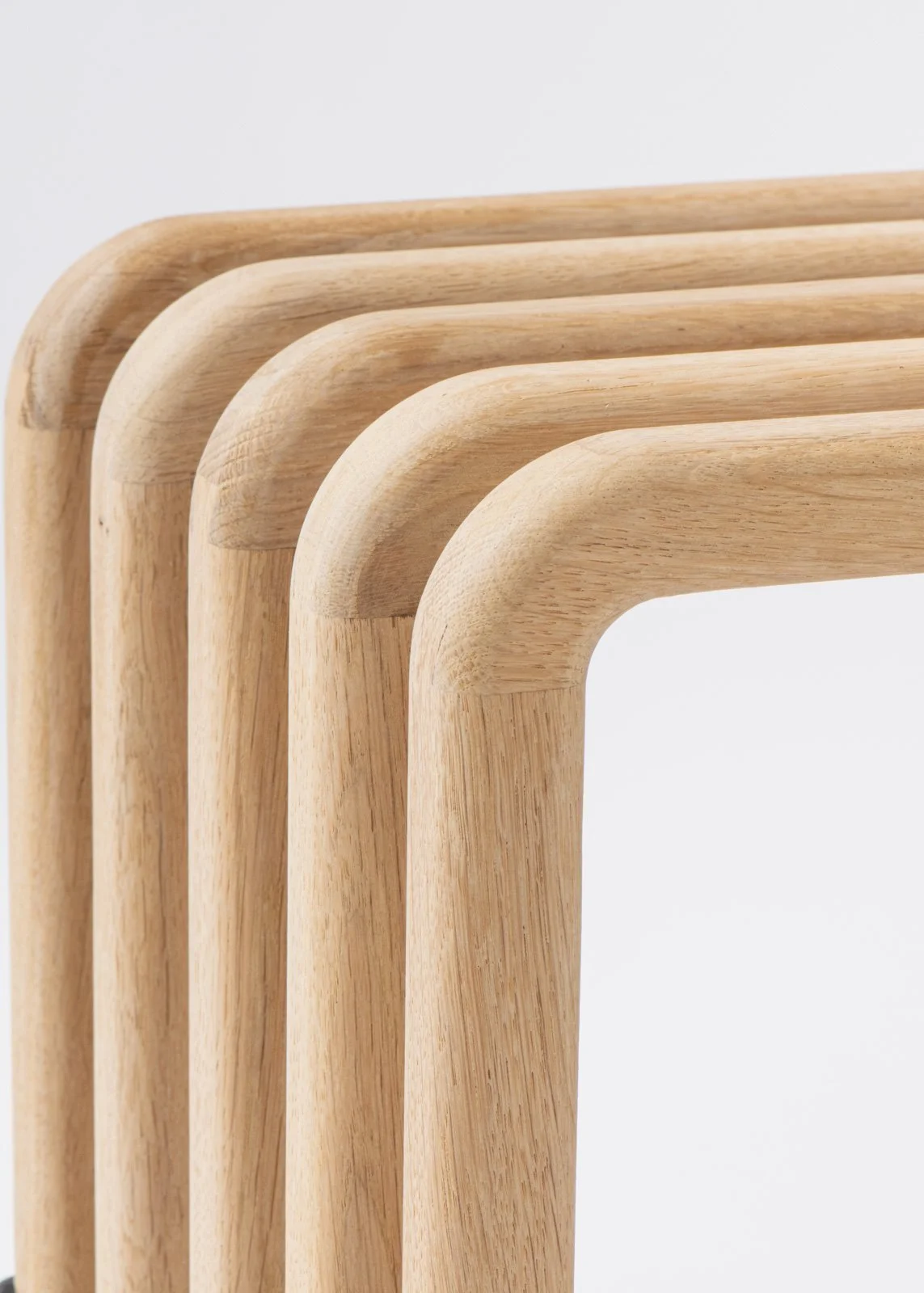 Quatre tables en bois naturel avec coins arrondis, empilées partiellement, sur fond blanc.