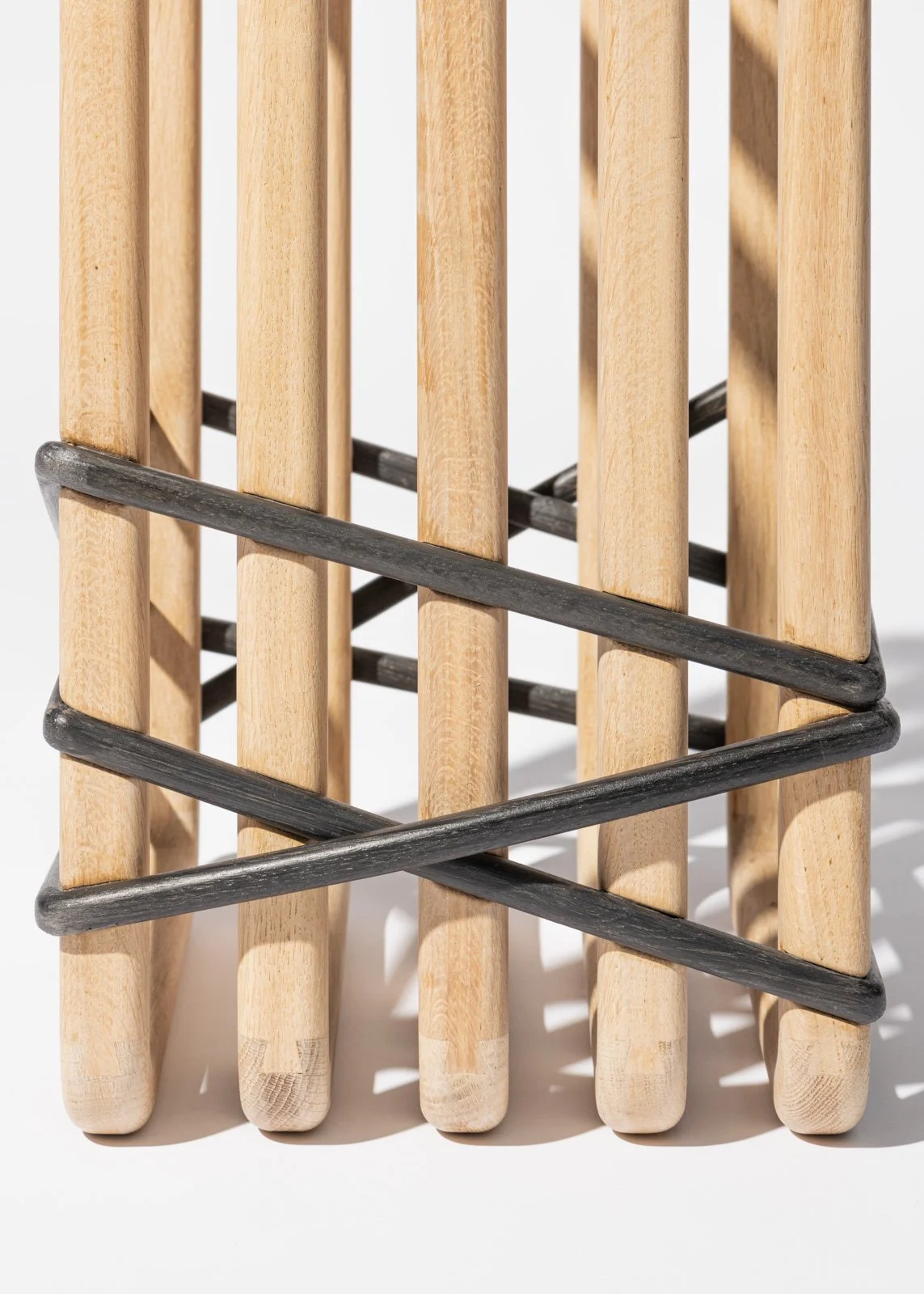 Une tabouret en bois avec des barres métalliques gravées en noire