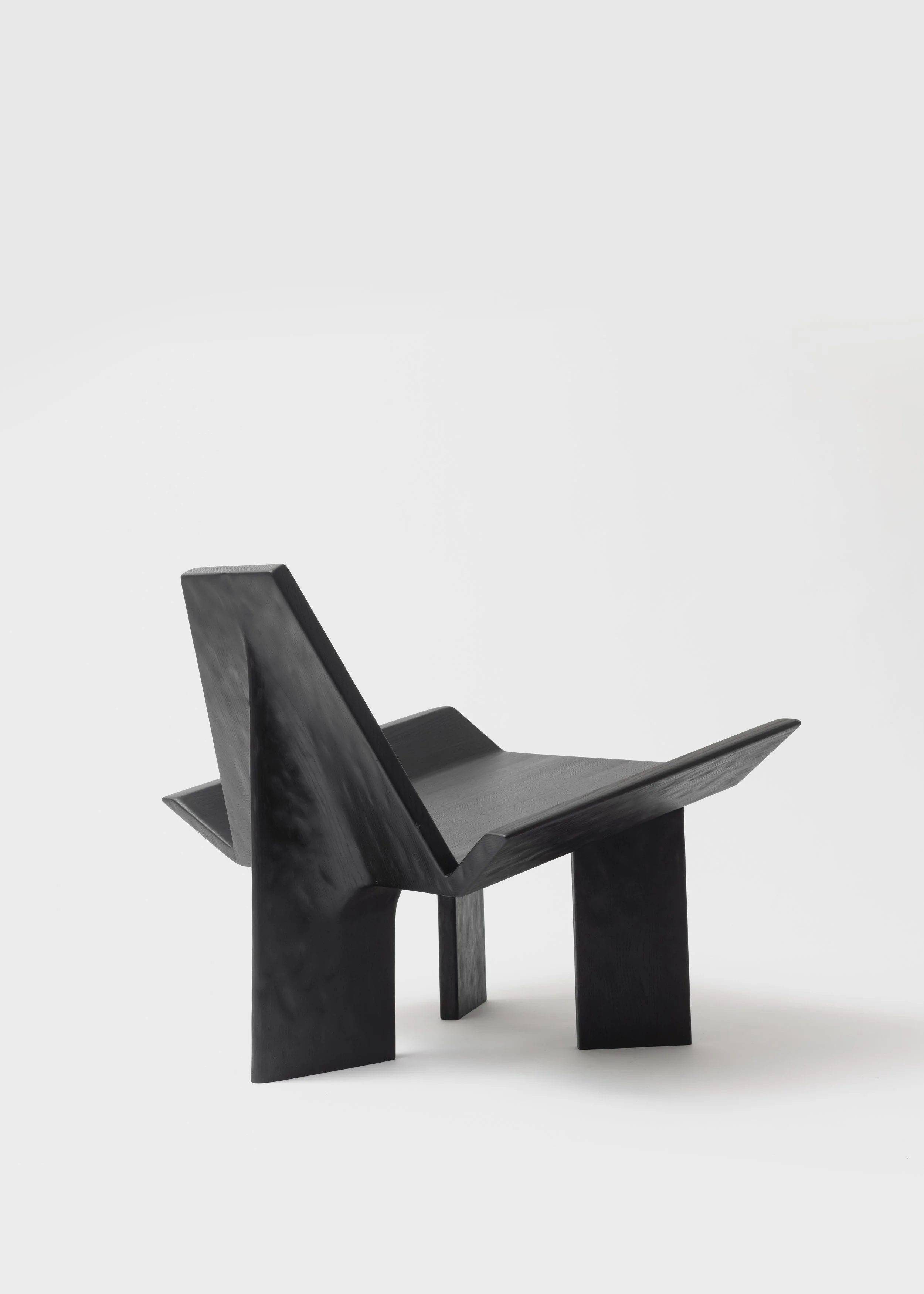 Fauteuil moderne en bois noir avec design minimaliste, placé sur un fond blanc.
