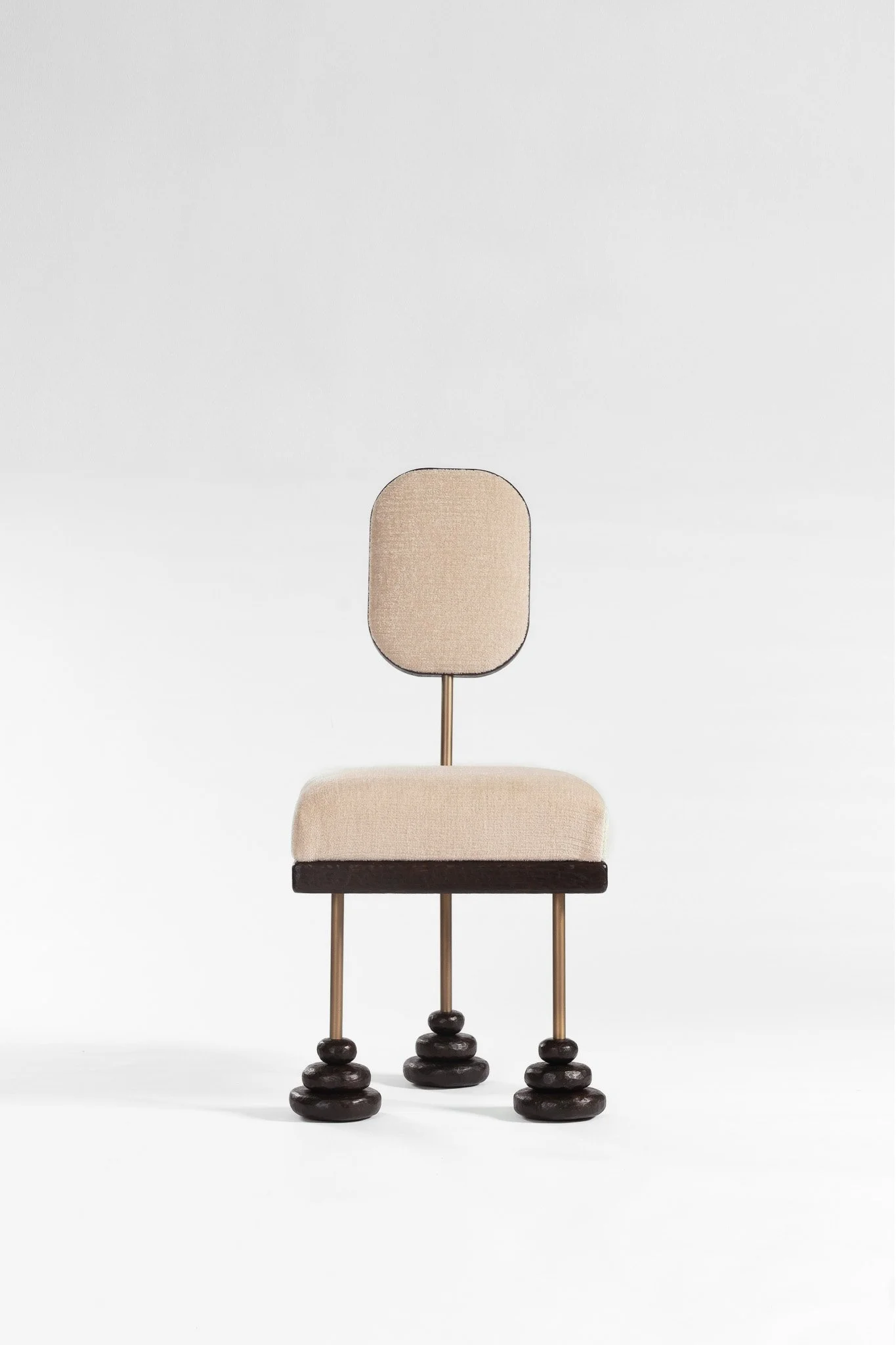 Chaise de style moderne avec un dossier et une assise en tissu beige, avec quatre jambes en métal brun et bases en bois sculpté en forme de pierres.