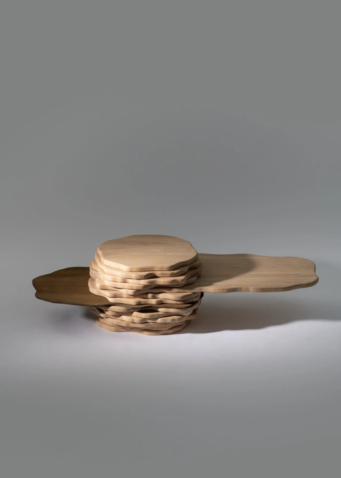 Table basse en bois naturelles sur un fond gris clair.