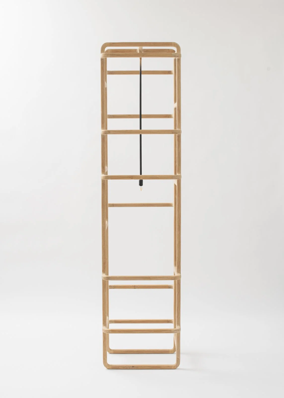 Une étagère en bois avec un éclairage noir suspendu au centre, positionnée contre un mur blanc.