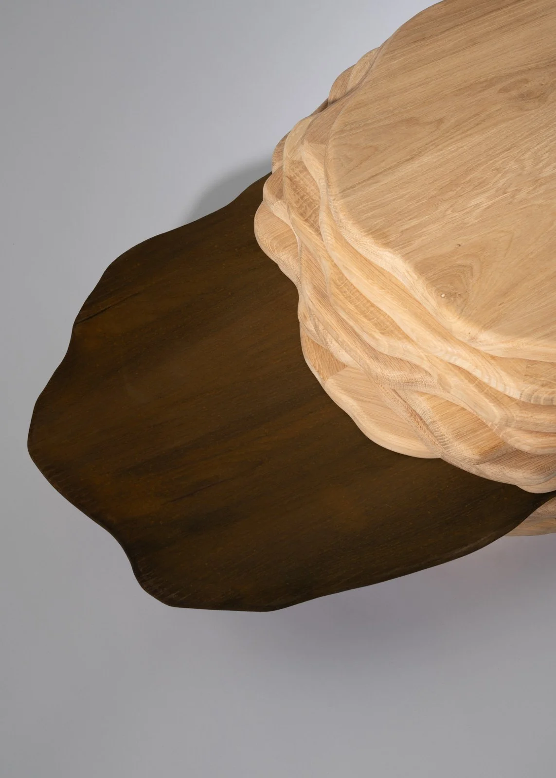 Une table en bois avec une surface sombre et une partie supérieure claire en bois naturel.